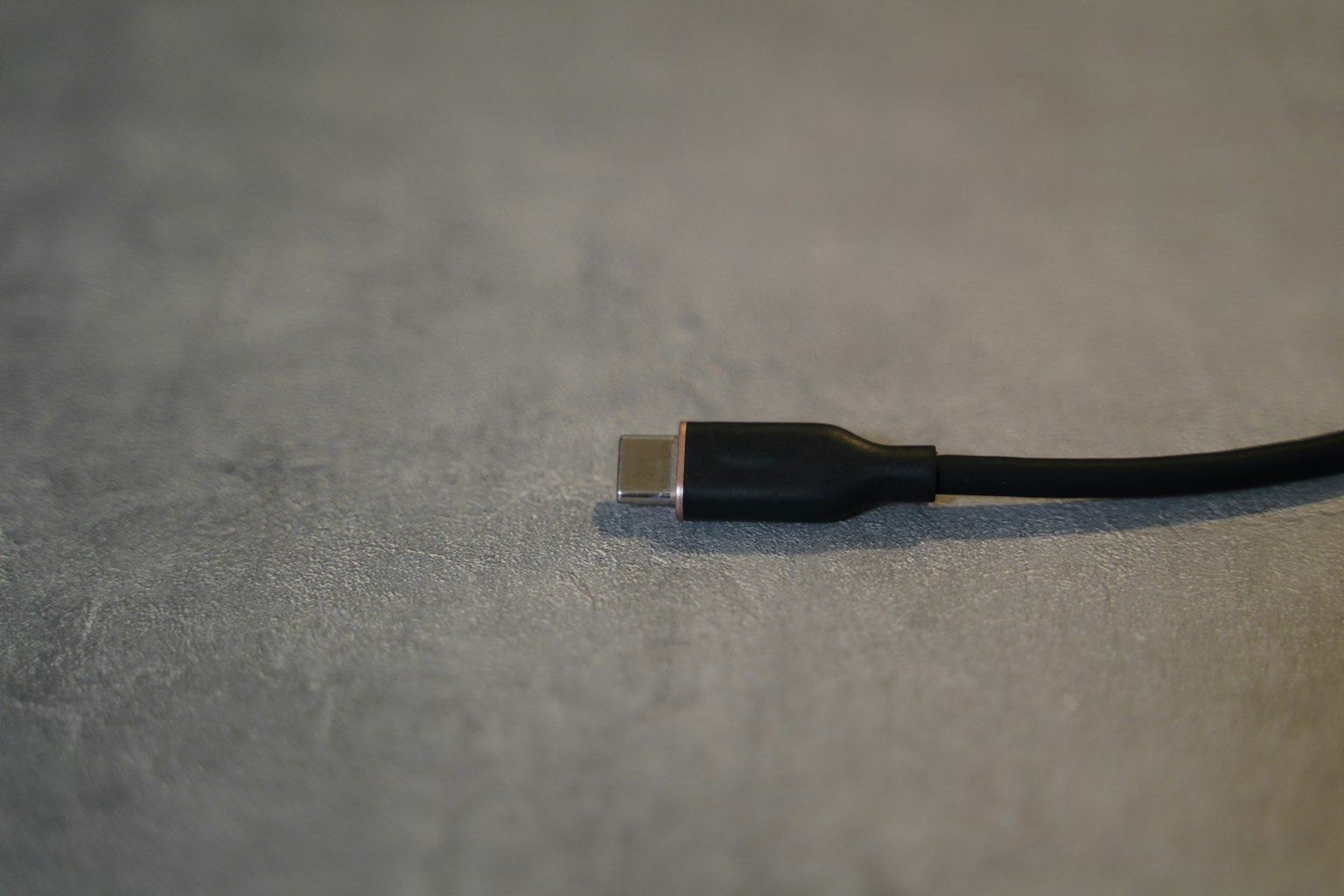 Schwarzes USB-Kabelende auf einer grauen Oberfläche