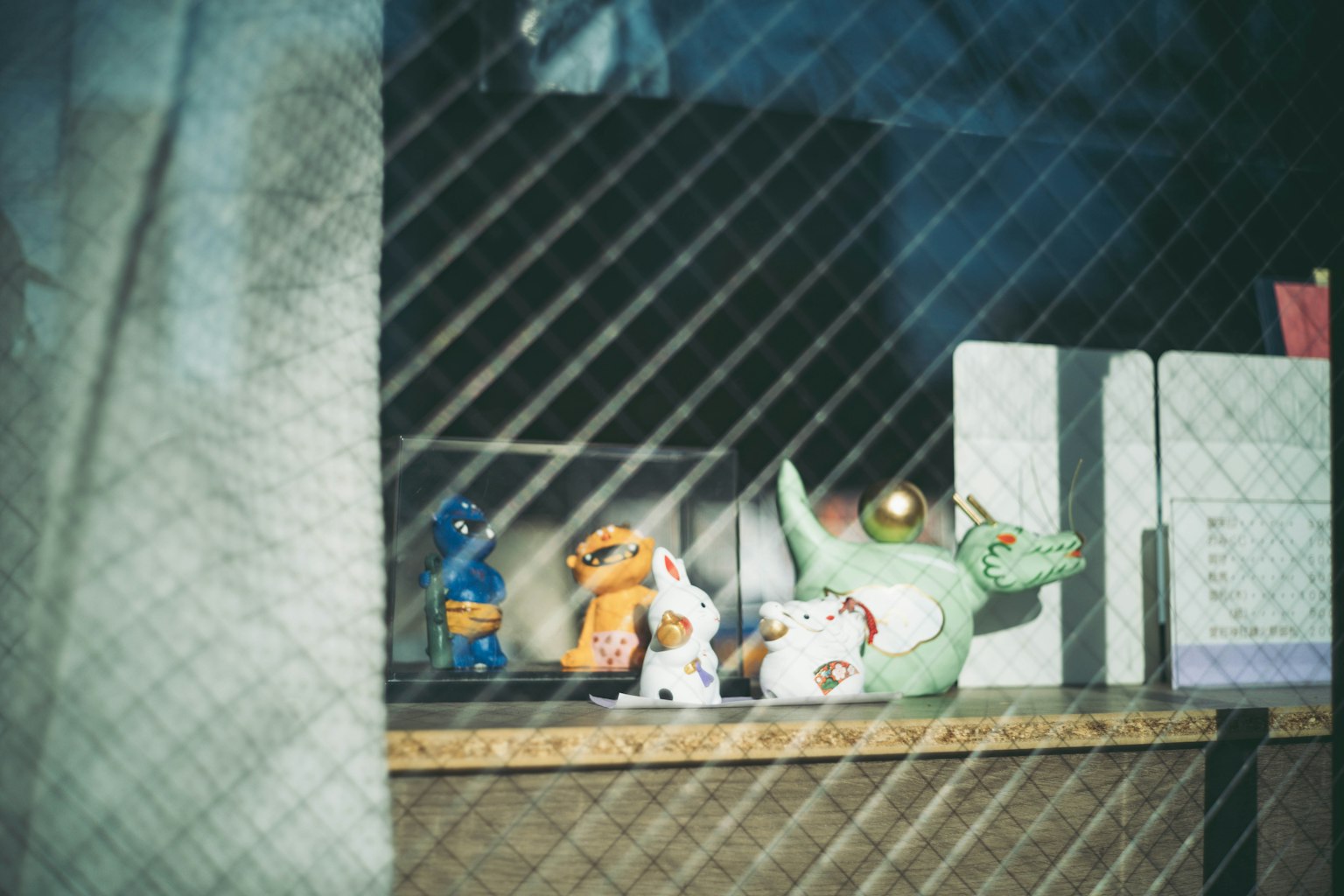 Colorful figurines on a shelf with blurred background light