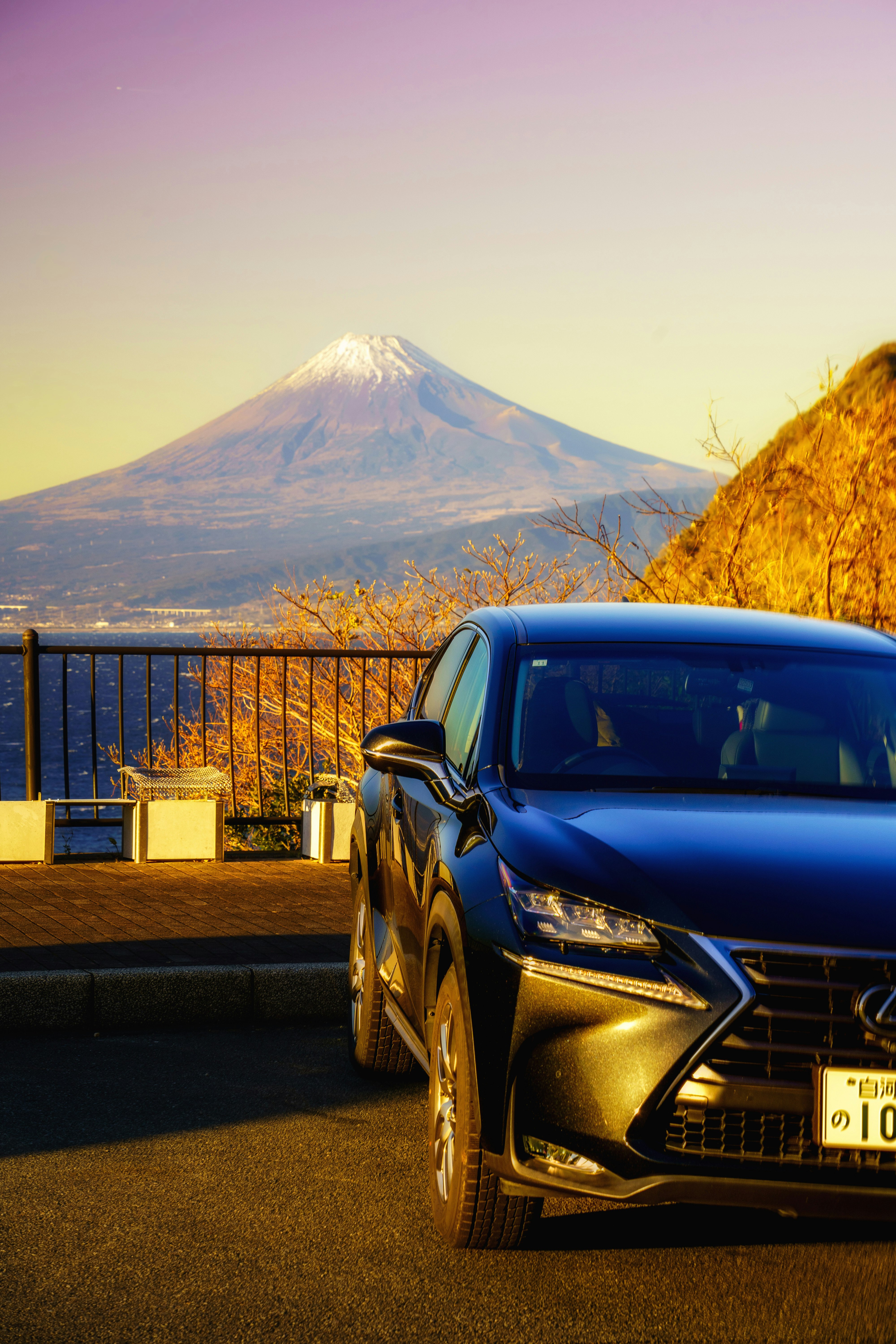 富士山を望む夕陽の下で停車するレクサス車