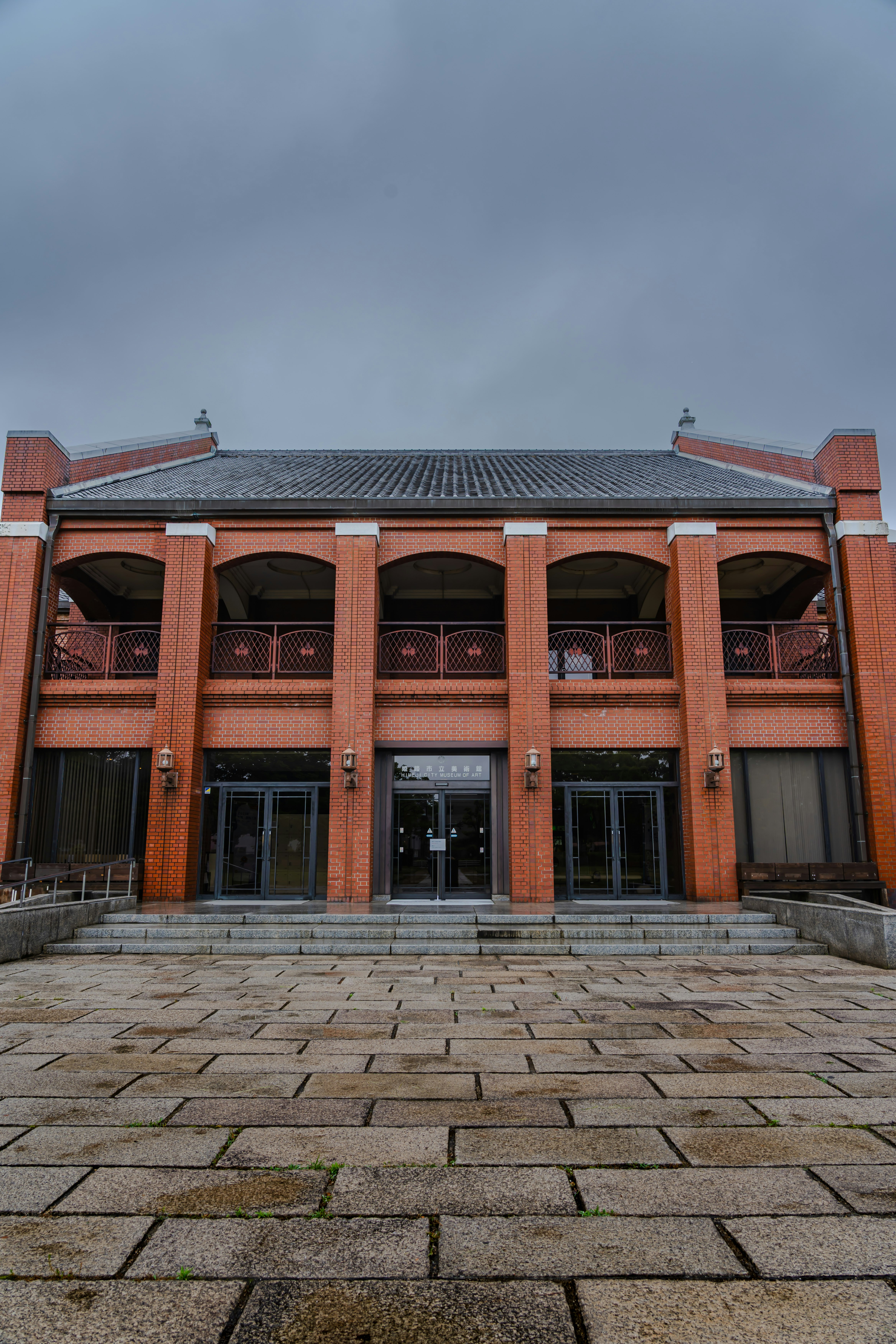 façade d’un bâtiment en briques rouges et allée pavée