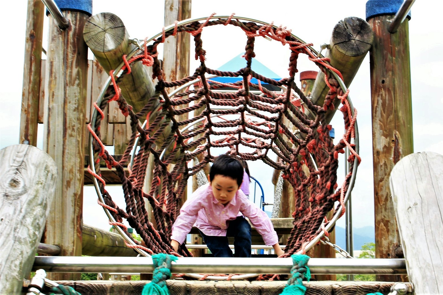 Ein Kind klettert durch einen Spieltunnel