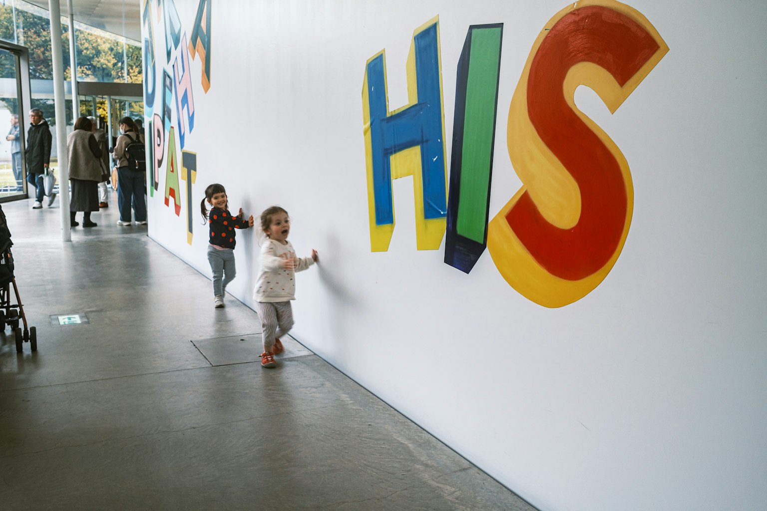 Bambini che interagiscono con lettere colorate su un muro