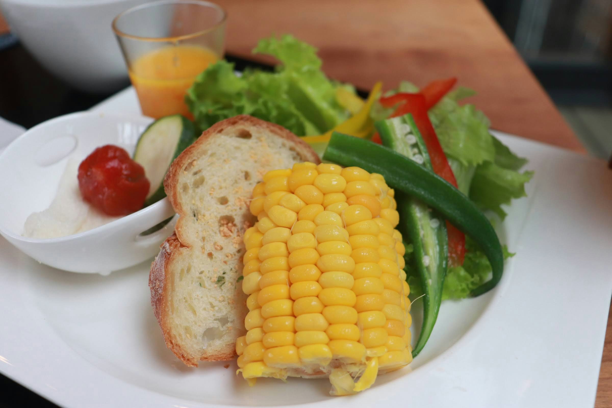 assiette avec maïs au beurre et salade de légumes