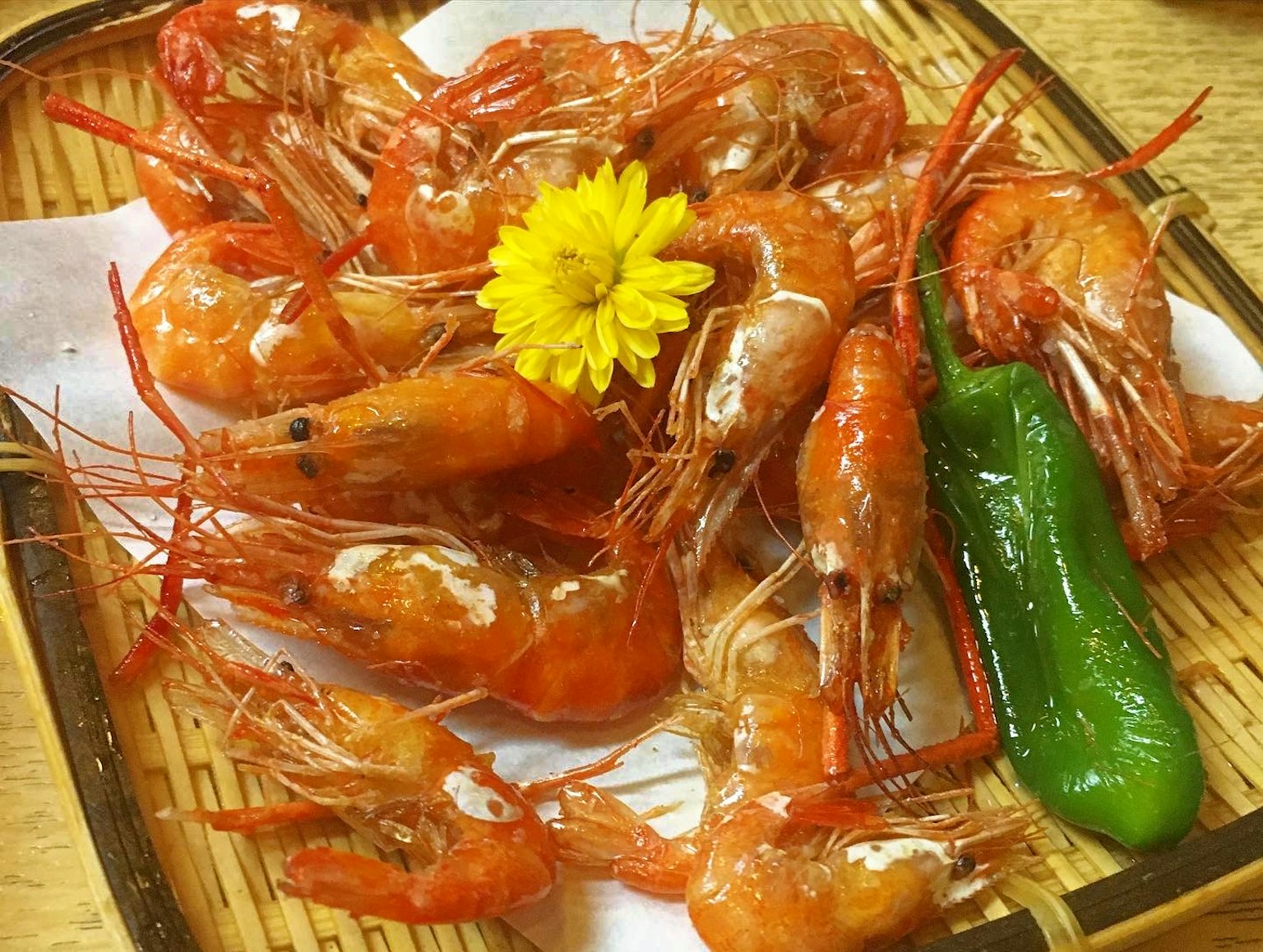 Piring udang dihias dengan bunga kuning dan cabai hijau