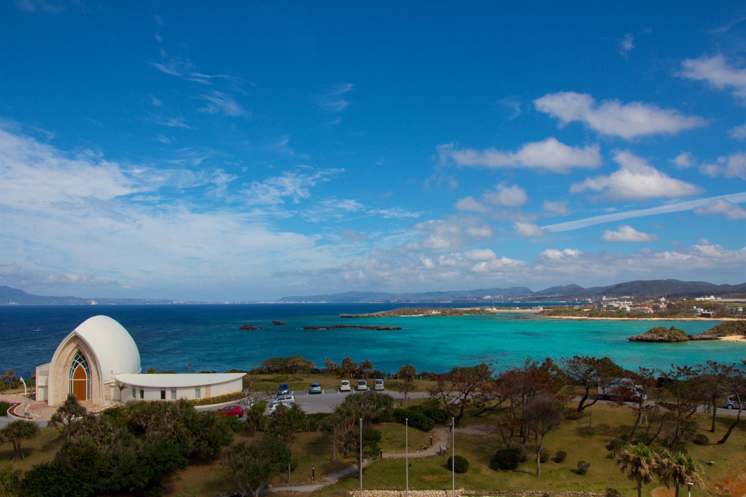 Vista panoramica dell'oceano e del cielo blu con un edificio vicino a Okinawa