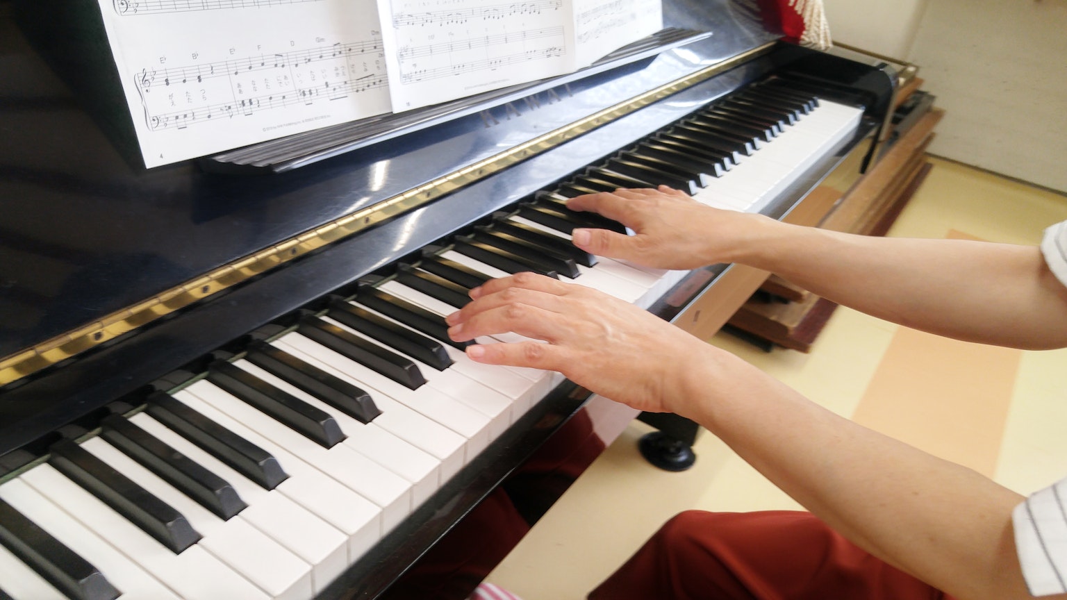Primo piano delle mani che suonano il pianoforte sui tasti bianchi e neri