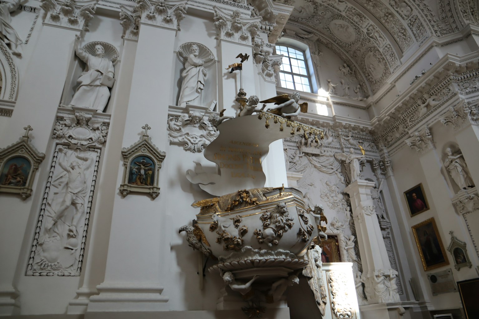 Intérieur d'une église avec des murs blancs ornés et une fontaine décorative