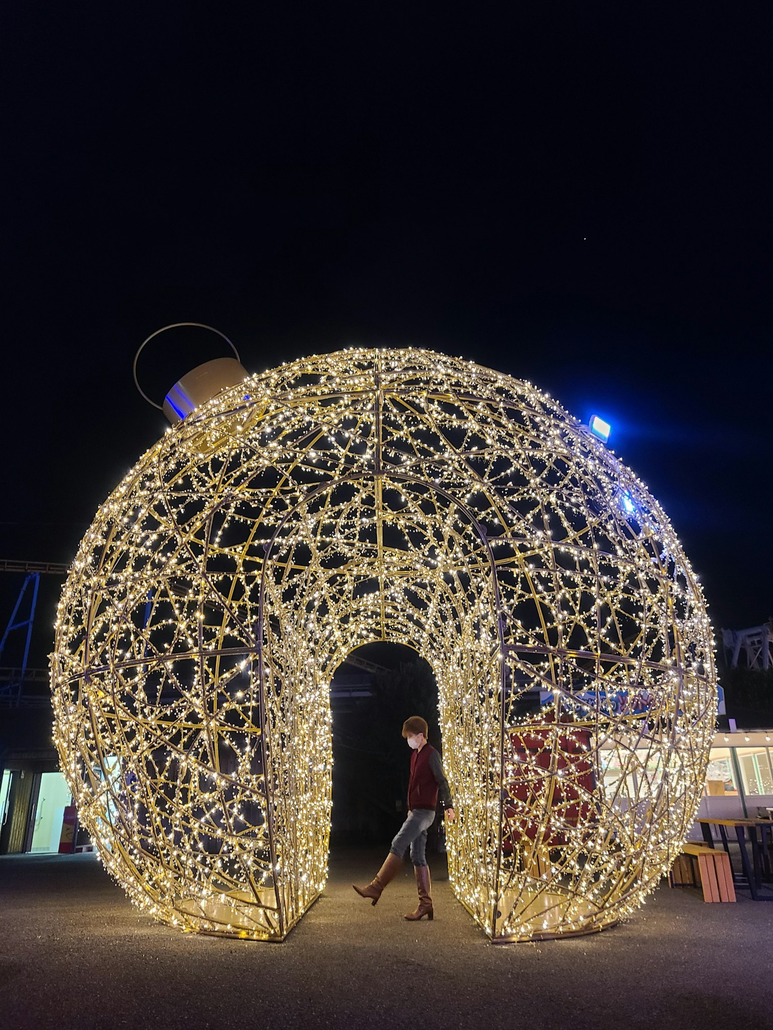 Persona che attraversa un arco luminoso decorativo di notte