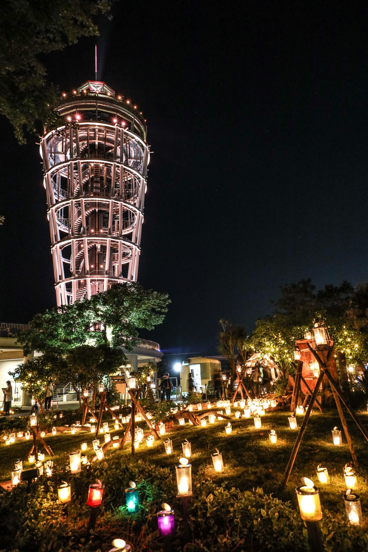 Nachtansicht eines Turms, der von Laternen im Garten beleuchtet wird