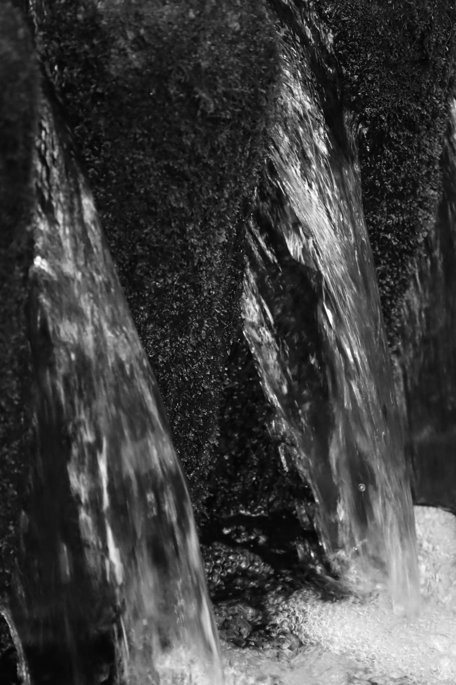 黒と白の水の流れが岩に落ちる様子