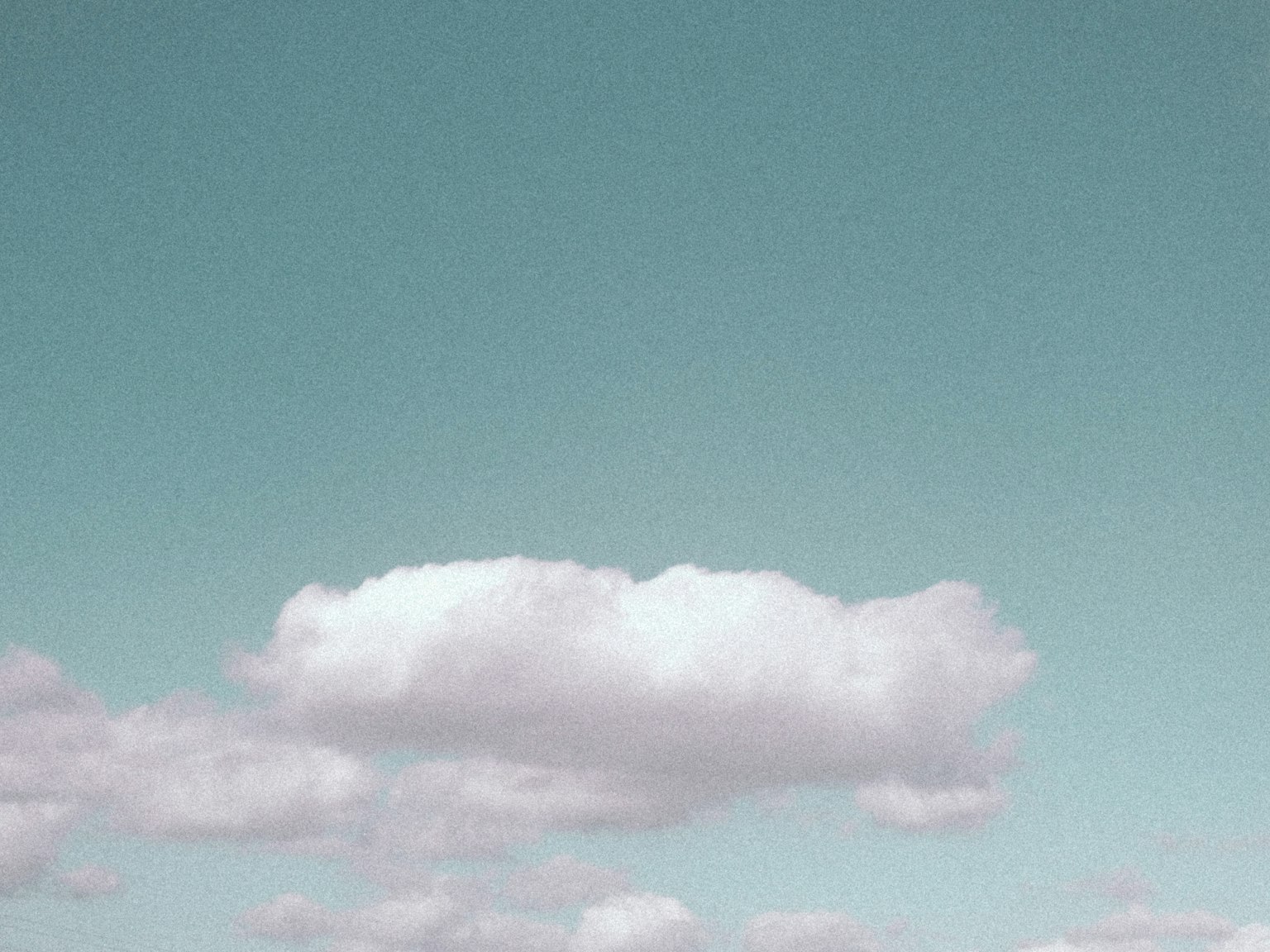 Ein ruhiger blauer Himmel mit flauschigen weißen Wolken