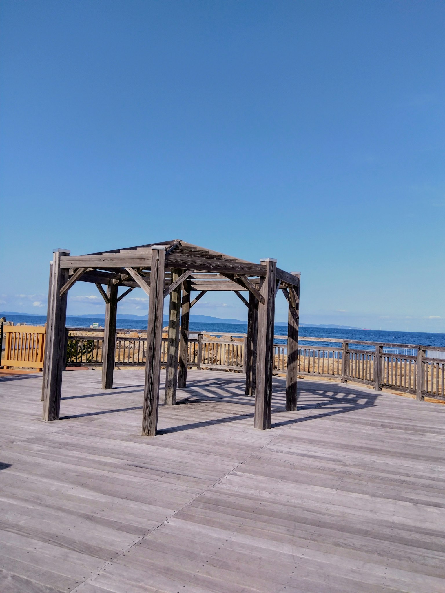 Pergola in legno con vista sull'oceano e cielo sereno