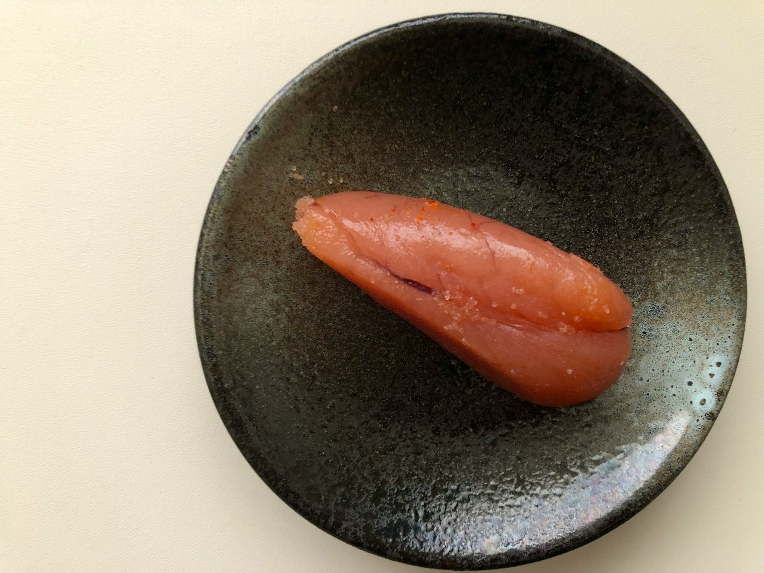 Red fish fillet on a black plate