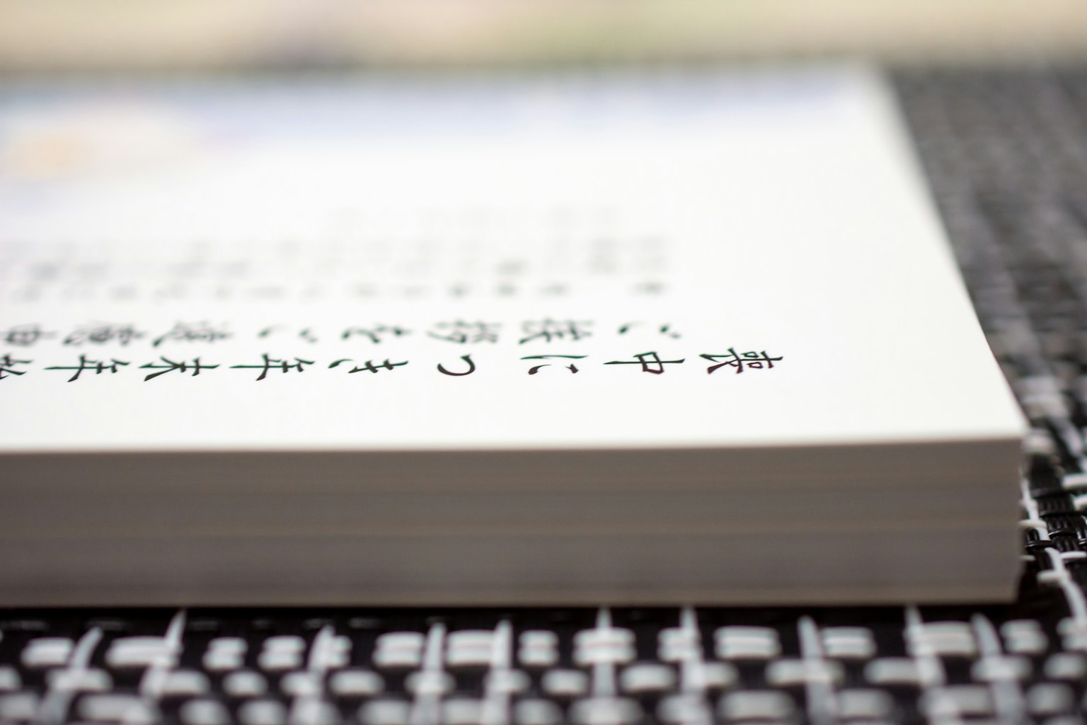 เอกสารภาษาญี่ปุ่นที่มีขอบข้อความมองเห็นได้วางอยู่บนโต๊ะสีดำ