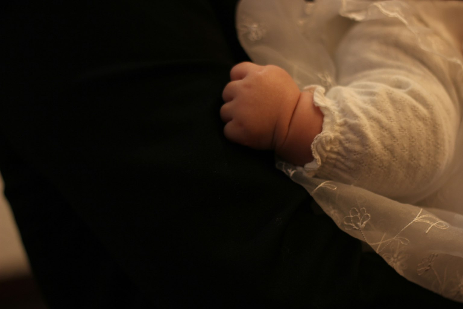 La mano de un bebé descansando sobre el brazo de un adulto