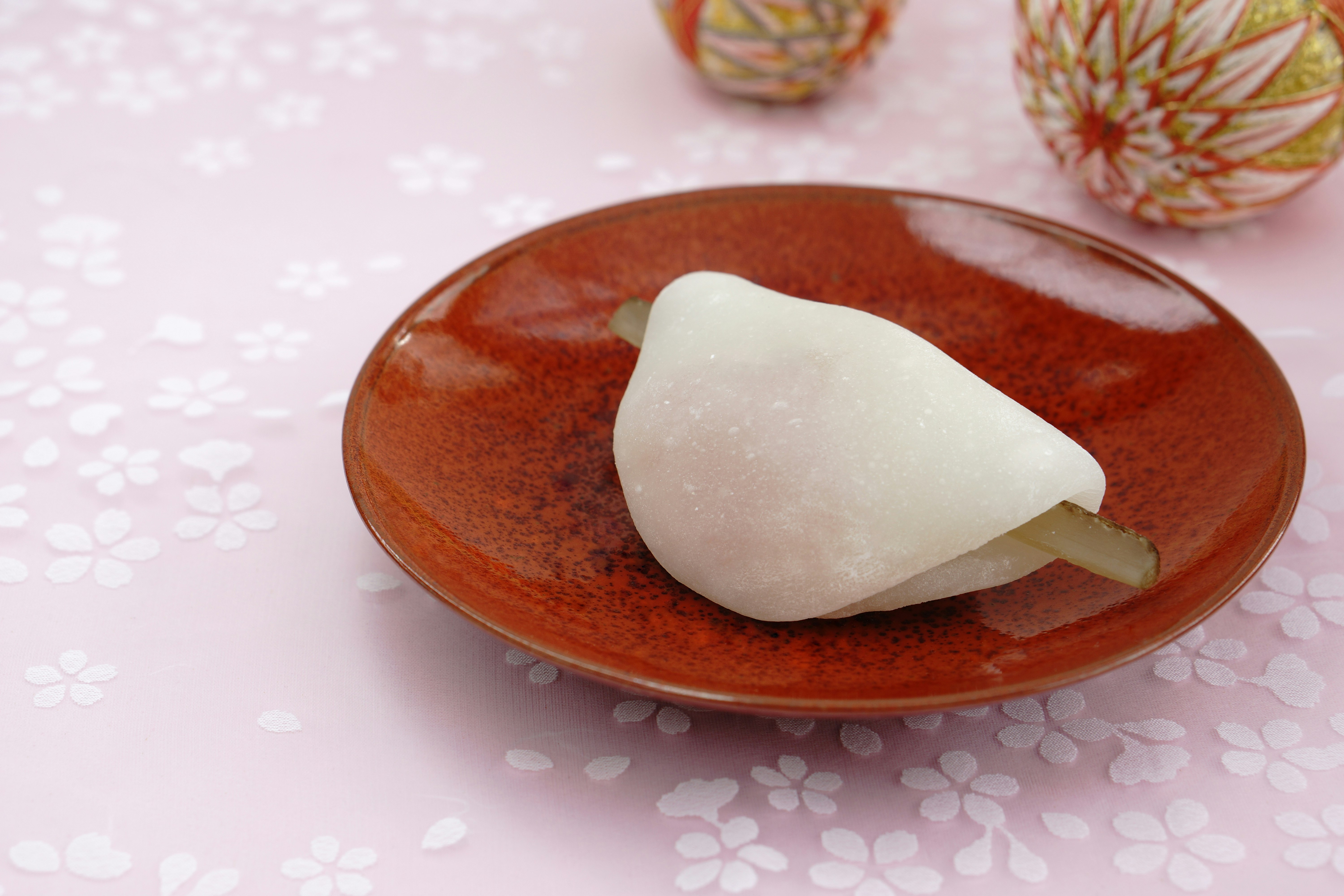 和菓子の白い餅がのった赤い銘々皿