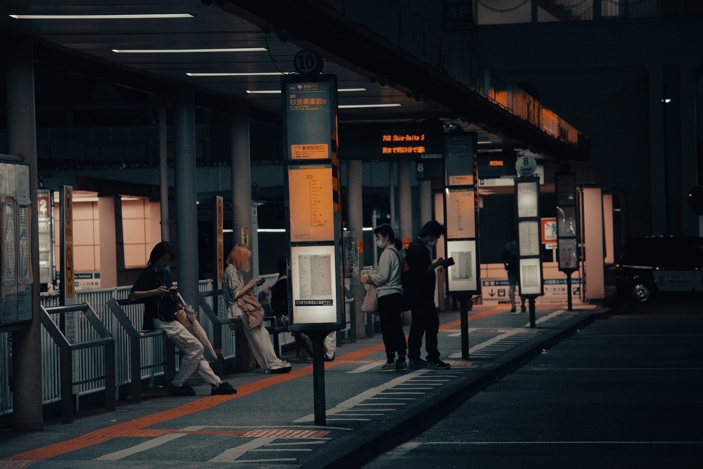 駅のホームで人々が並ぶ夜の通路