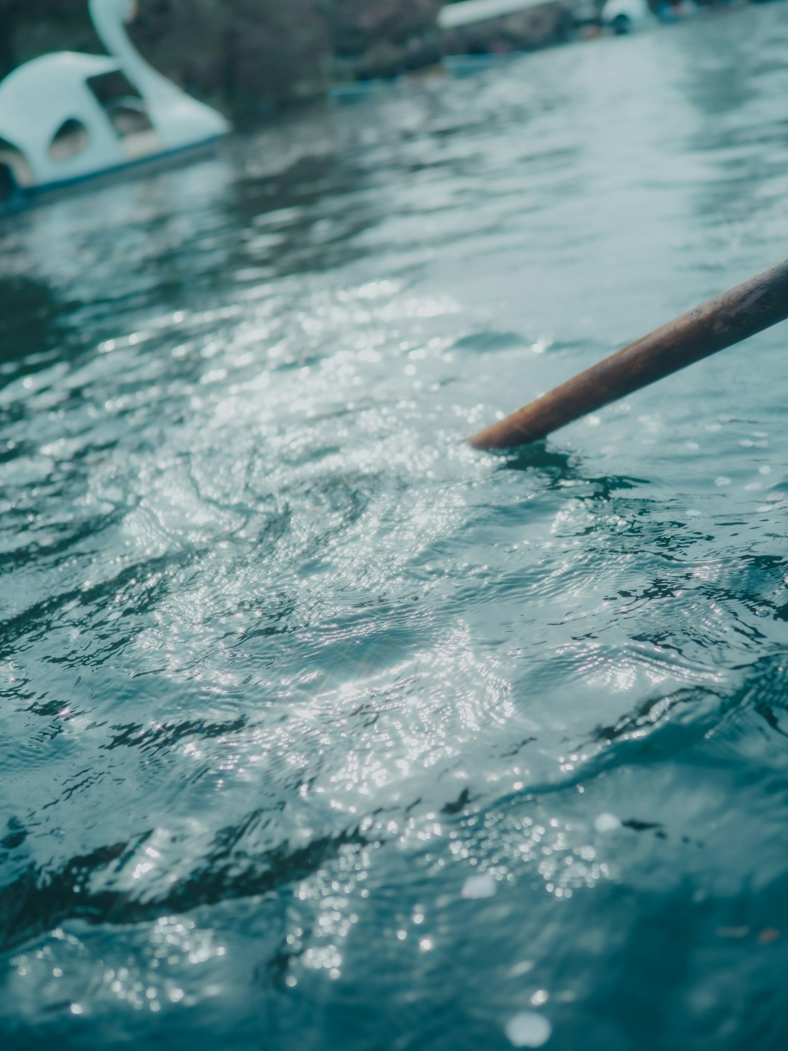 Foto della superficie dell'acqua scintillante con un bastone di legno