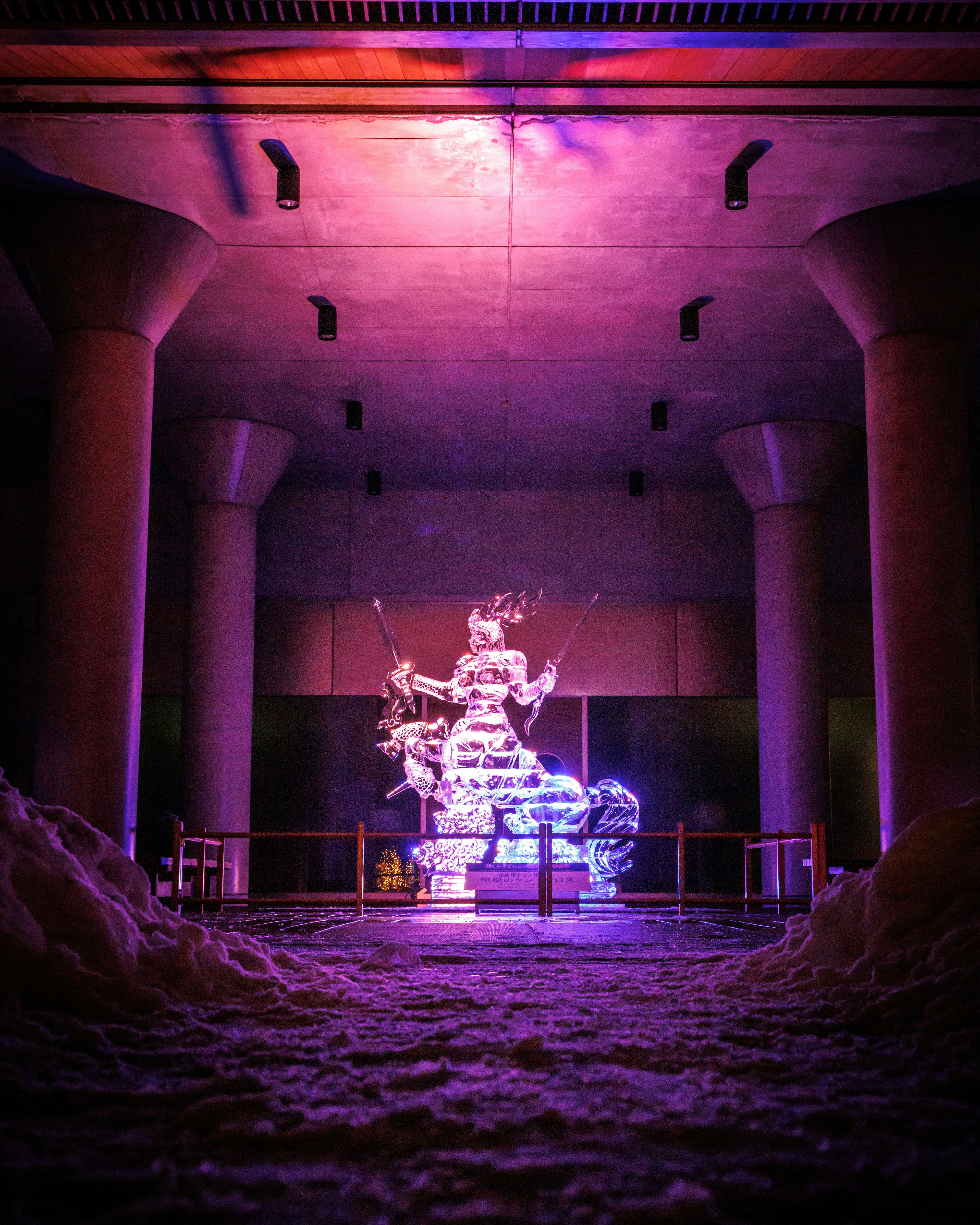 Espacio de exposición interior con una escultura de hielo de un centauro