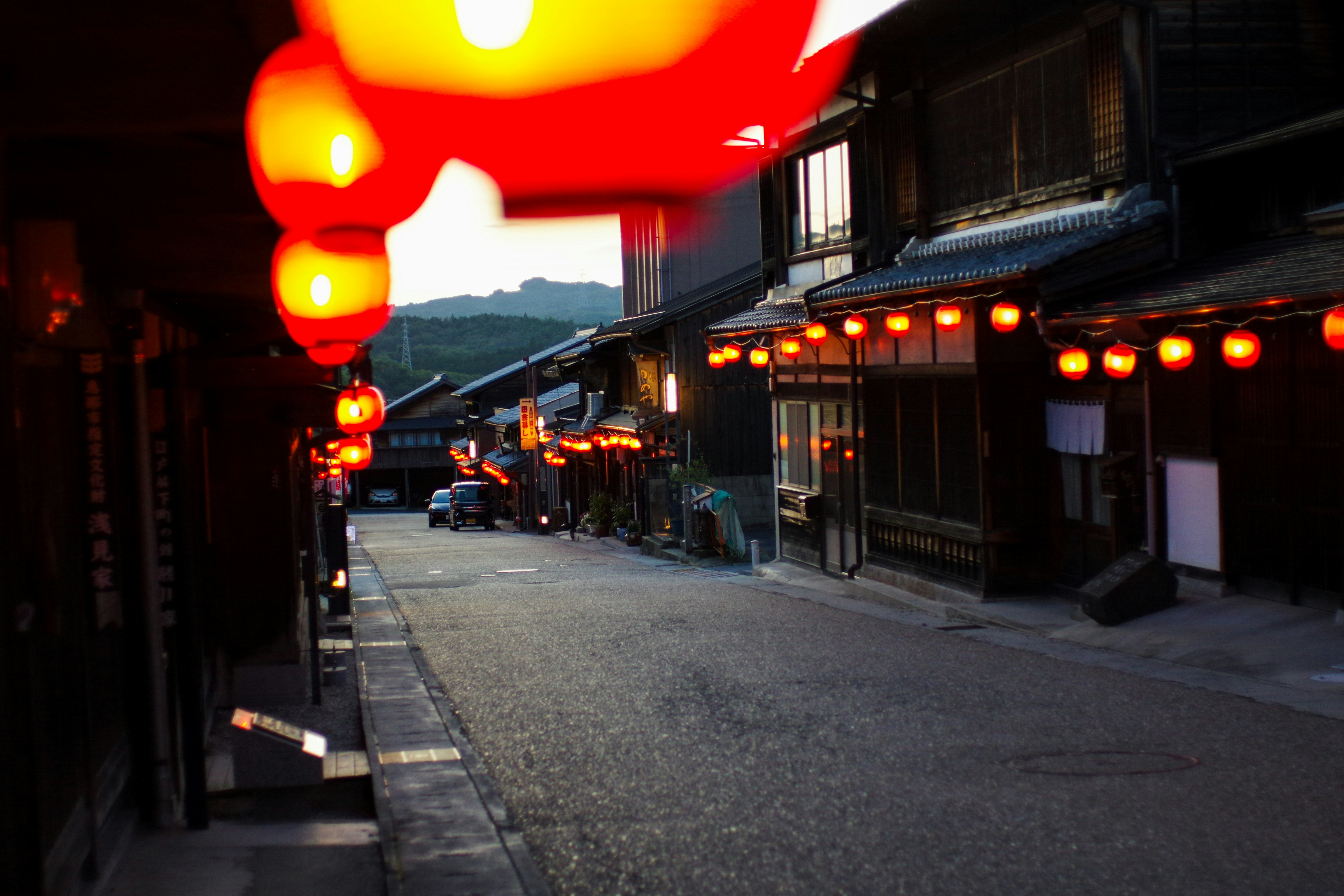 夕暮れの提灯が灯る路地の商店街の軒先