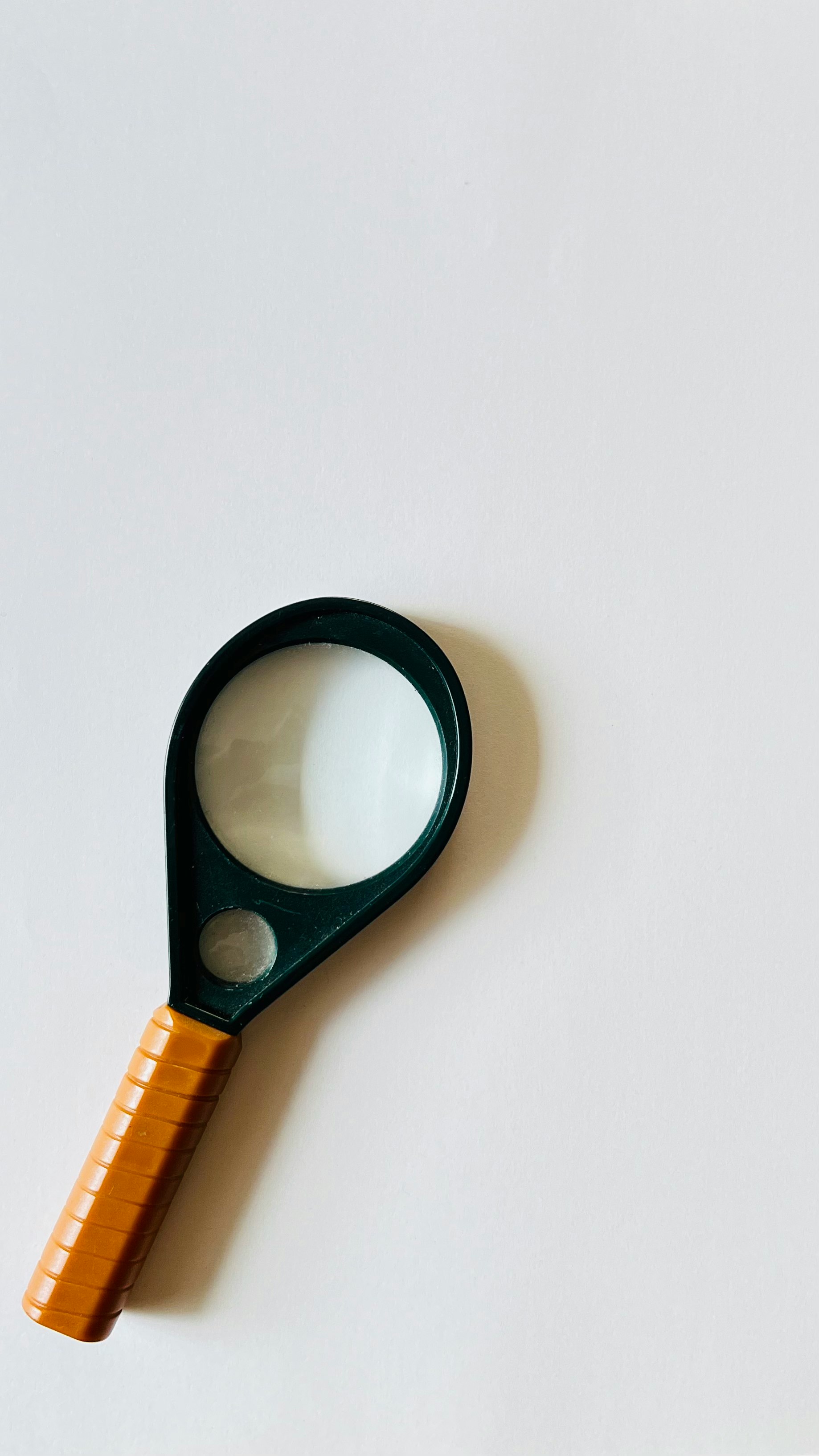 magnifying glass and orange ruler on a white background