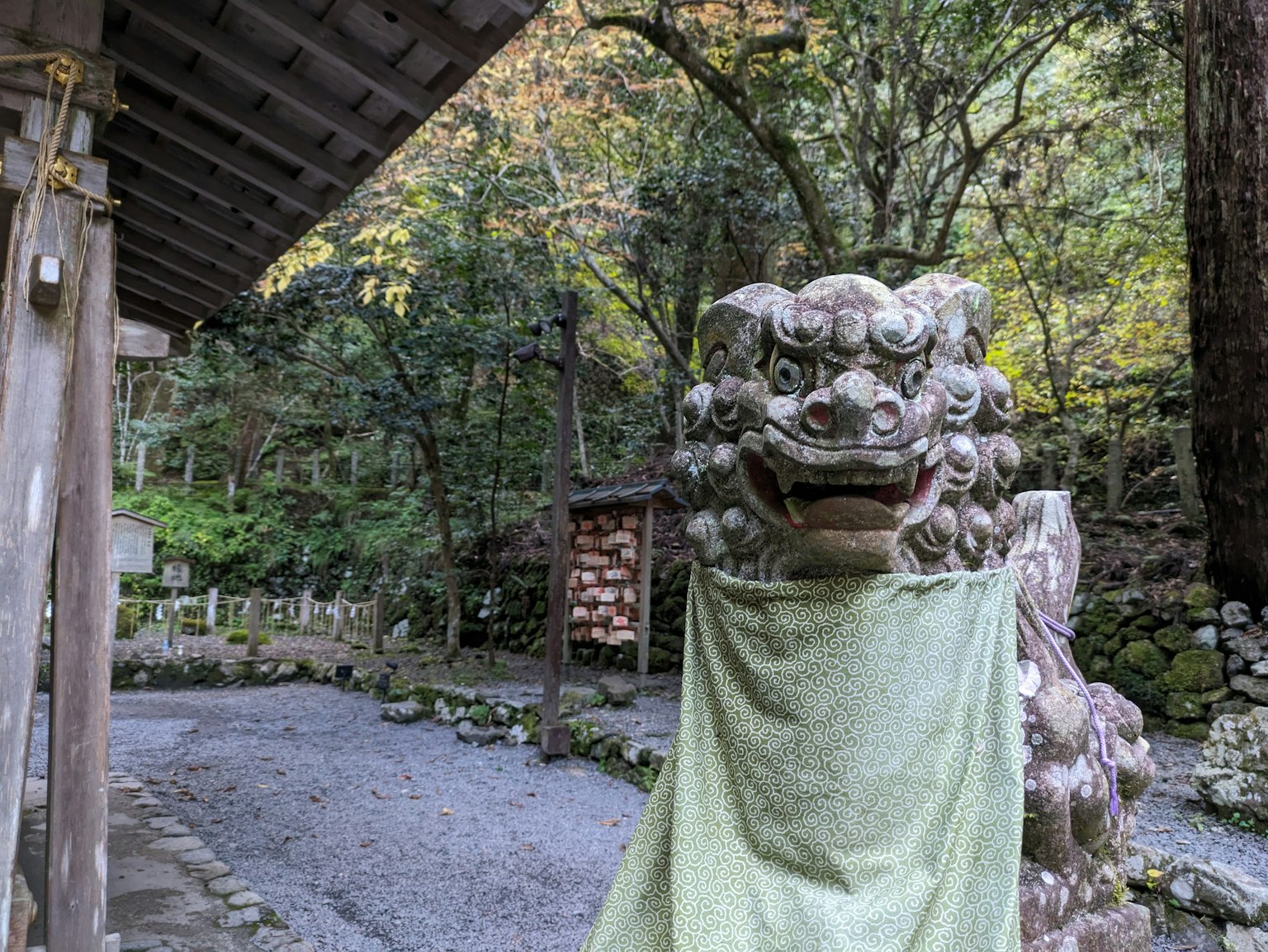 A serene view of a temple komainu covered with a green cloth