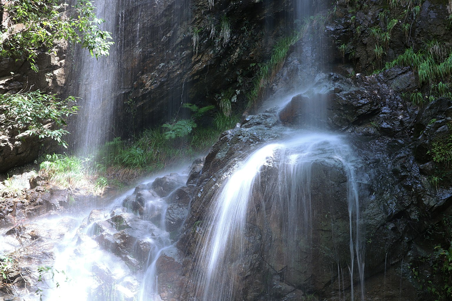 Una hermosa cascada que cae sobre rocas en un entorno natural