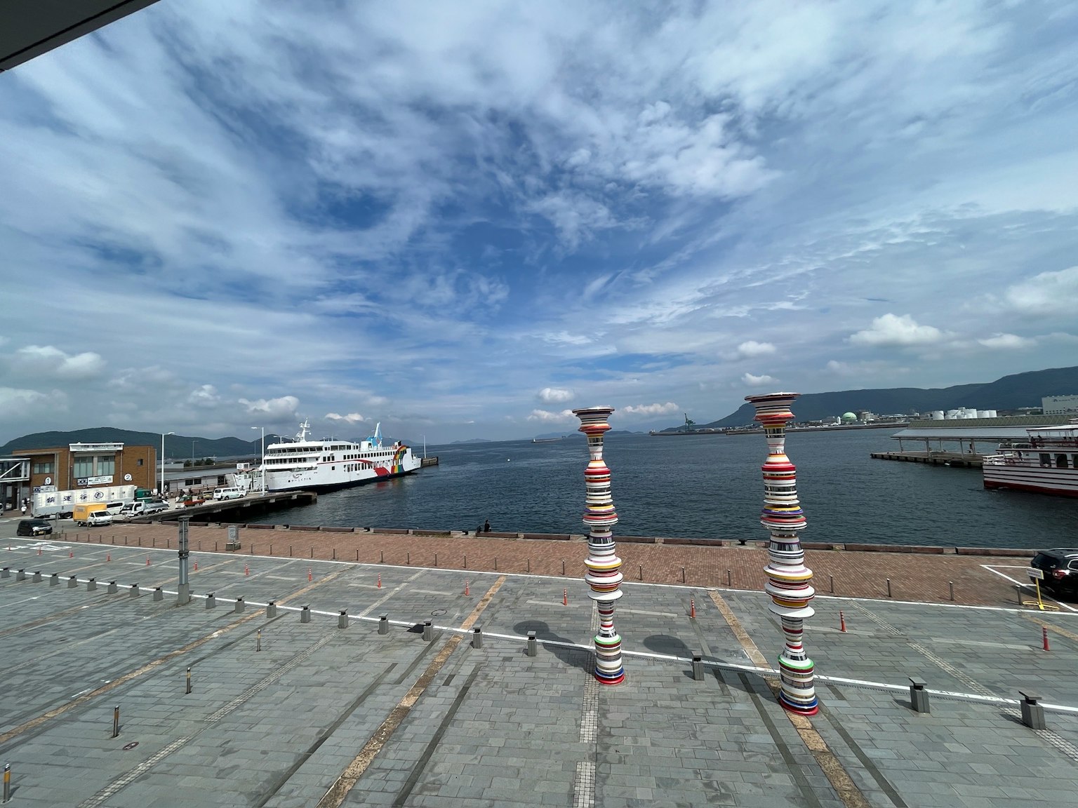 Piloni colorati in una scena di porto con cielo azzurro