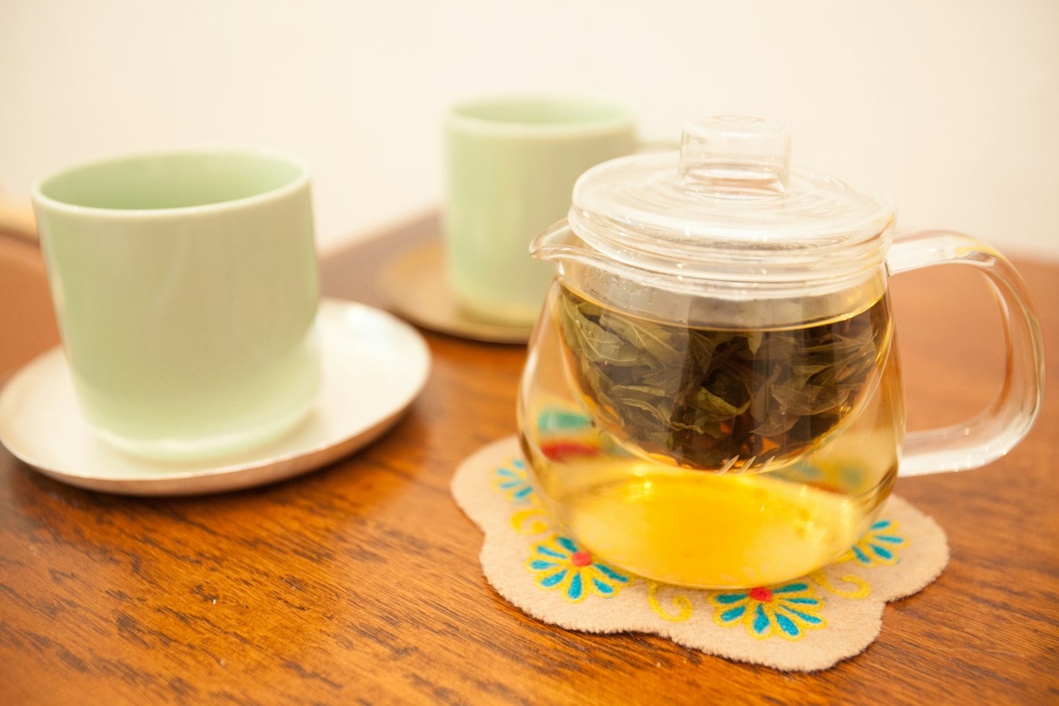 Imagen de tazas verdes y una tetera llena de té