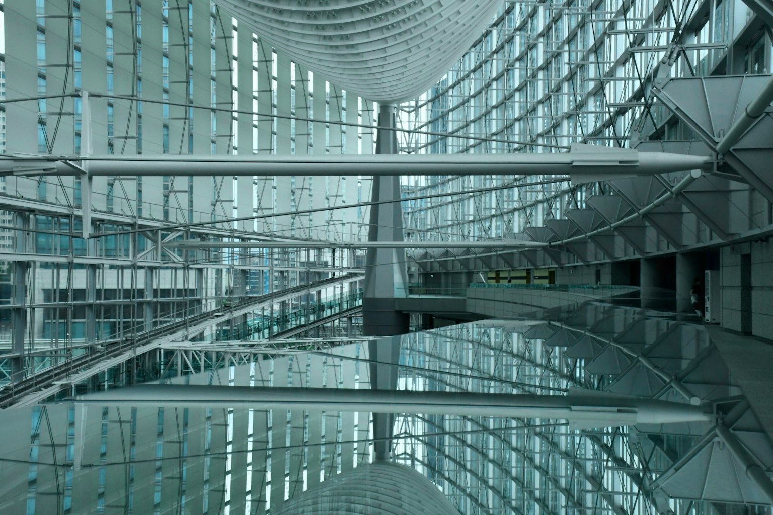 Interno architettonico moderno con superfici riflettenti e pareti di vetro luce soffusa che entra nello spazio