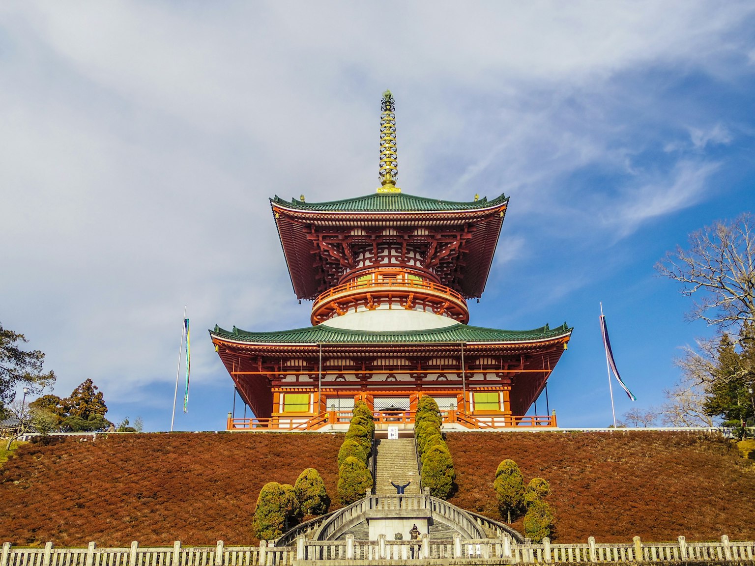 โครงสร้างวัดที่สวยงามใต้ท้องฟ้าสีฟ้าพร้อมหลังคาสีเขียวและการออกแบบที่ประดับประดา