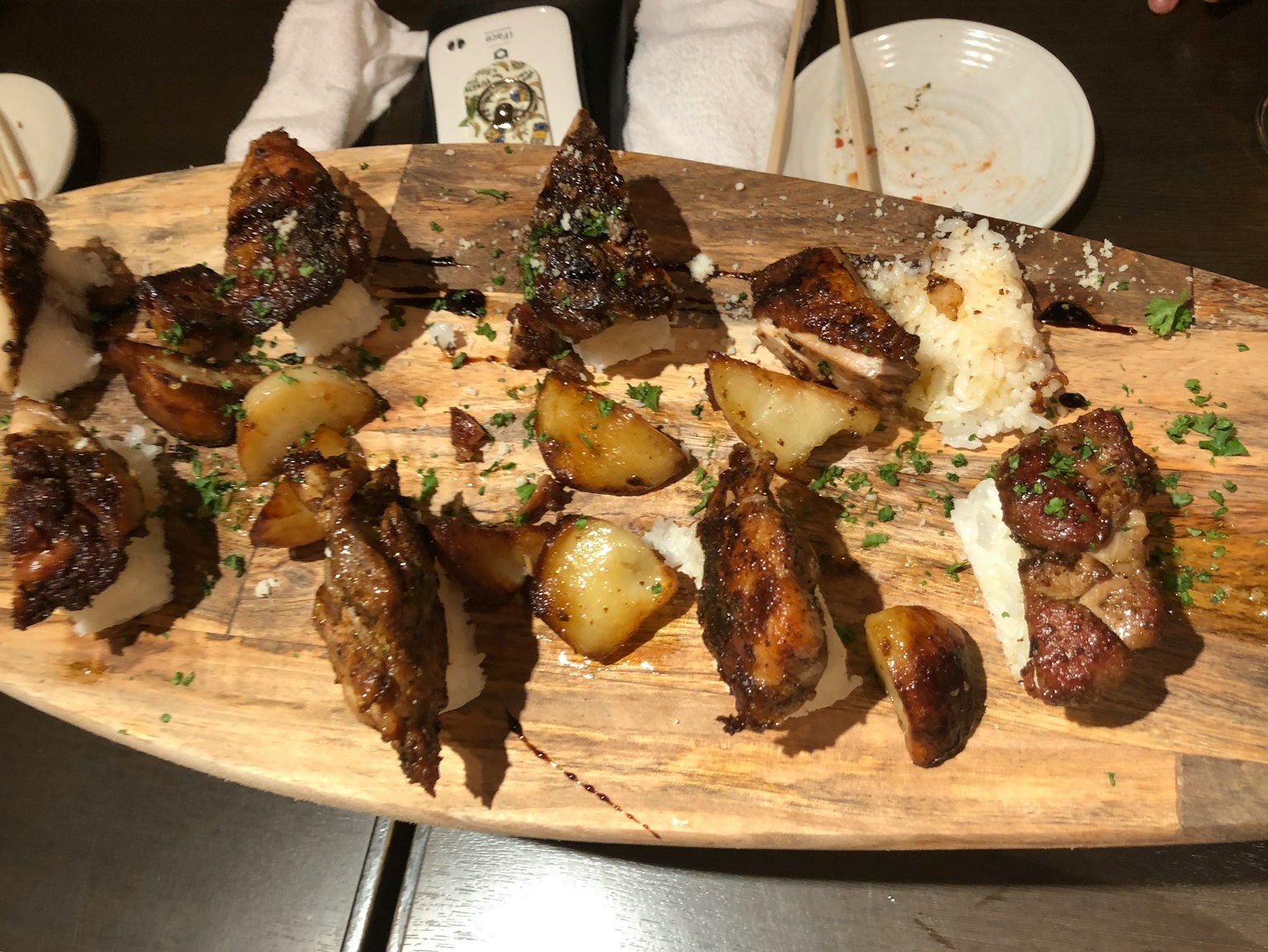 Carne alla griglia e patate servite su un vassoio di legno