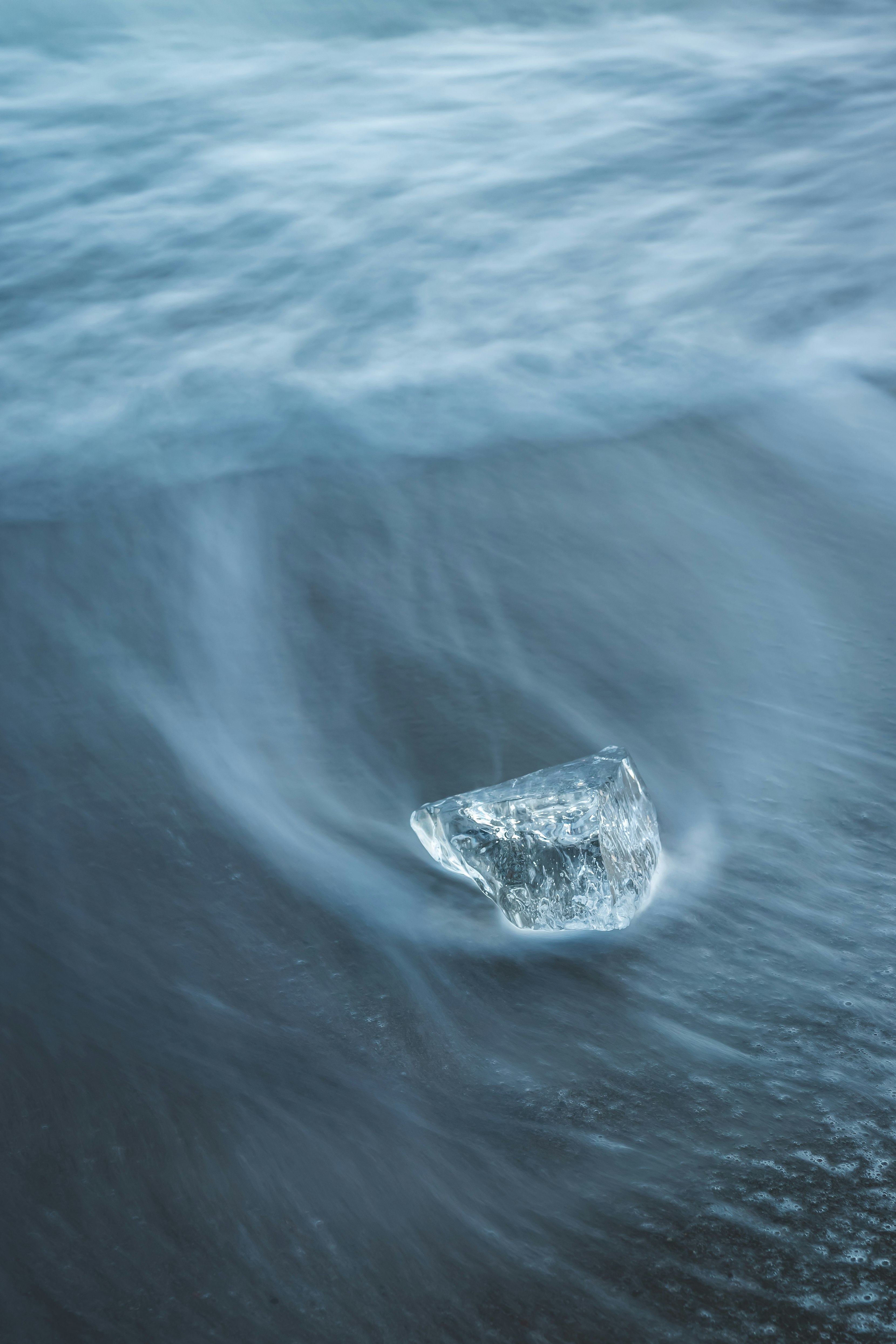 波の中に浮かぶ透明なプラスチック片のような物体
