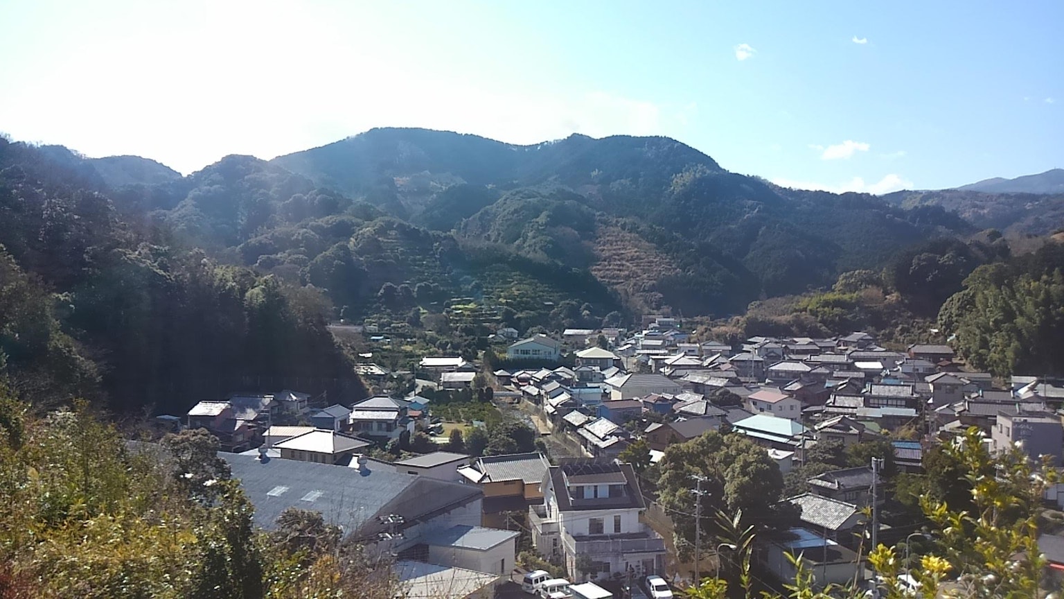 Vista panoramica di un piccolo villaggio circondato da montagne e cielo blu