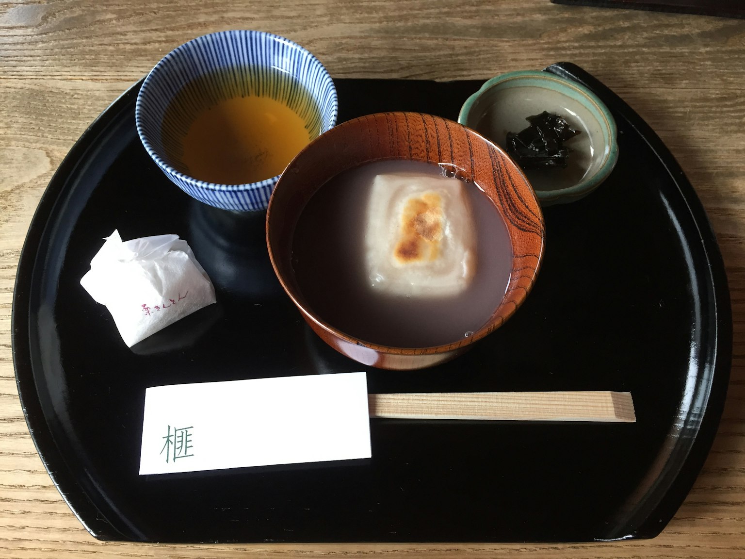 Puding Jepang dan teh hijau disajikan di atas nampan hitam