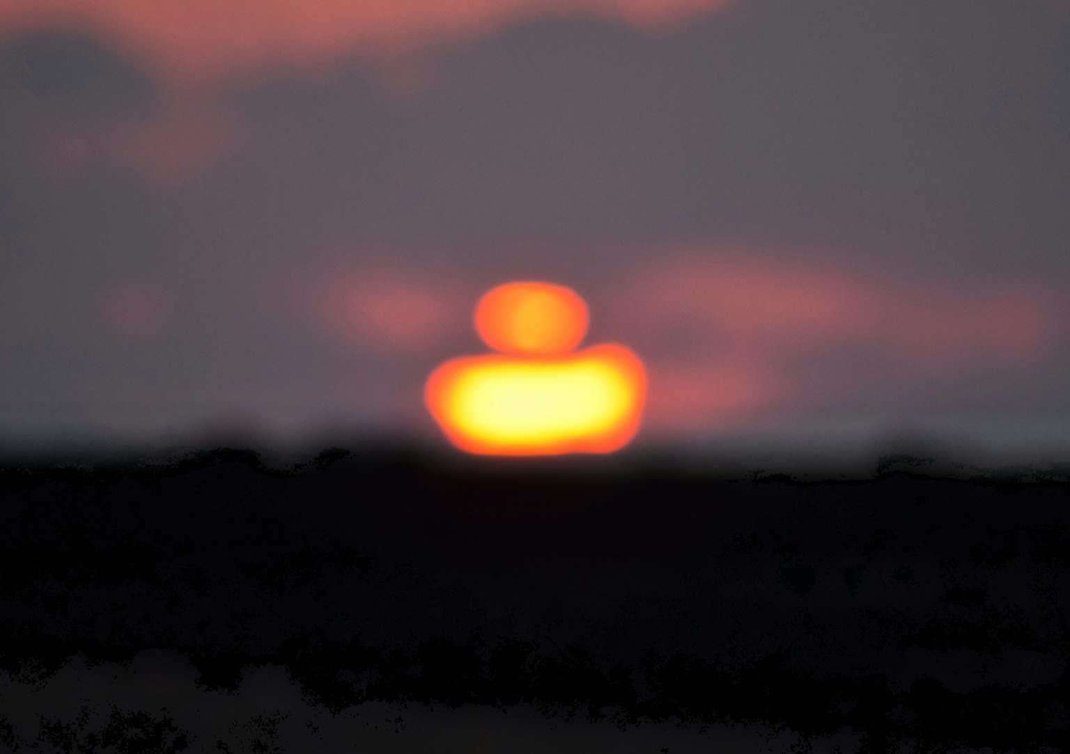 Verschwommene Sonne mit leuchtendem Orb über dem Horizont