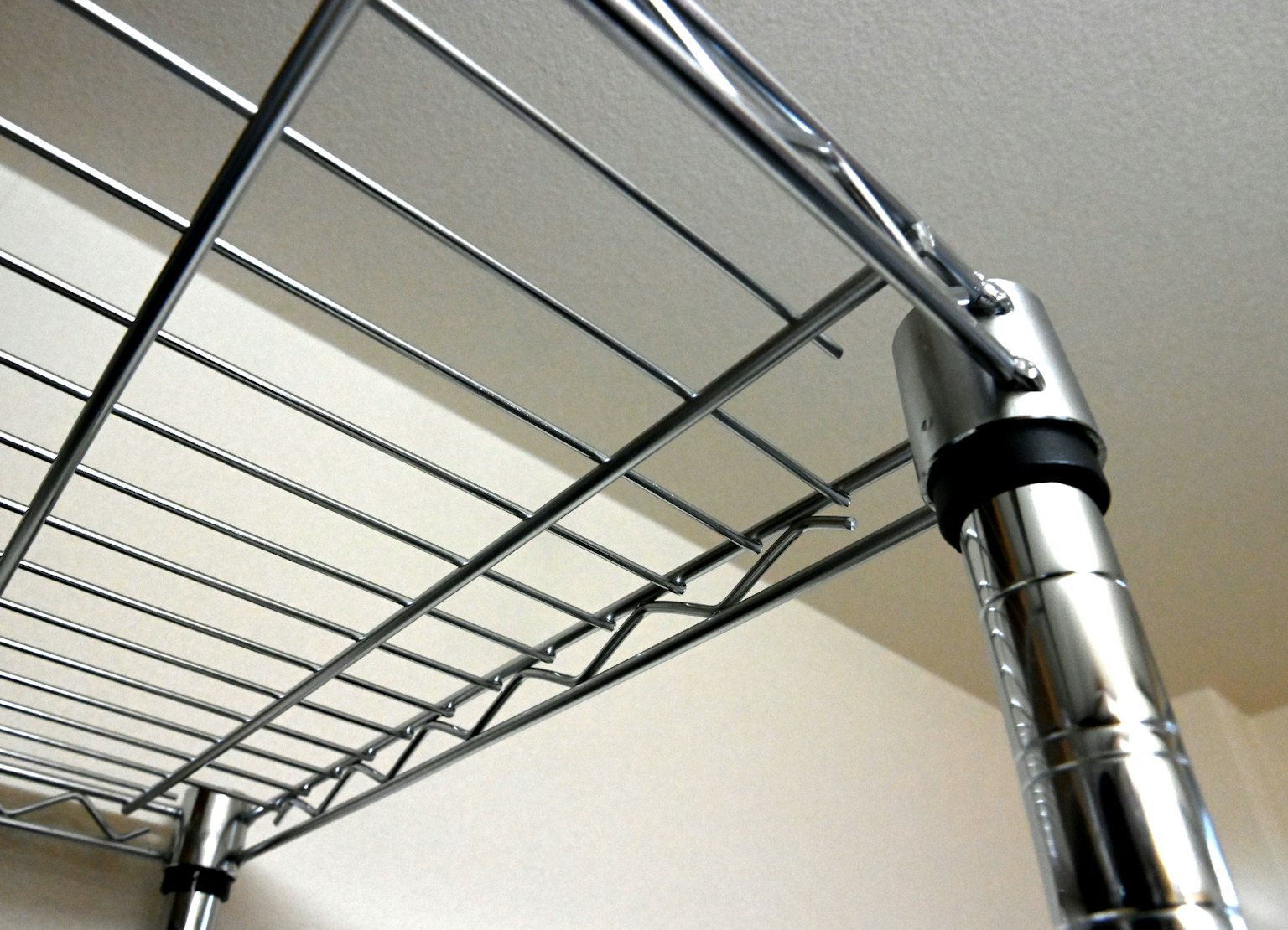 Gros plan d'une étagère en métal montrant une finition en chrome et un motif en grille
