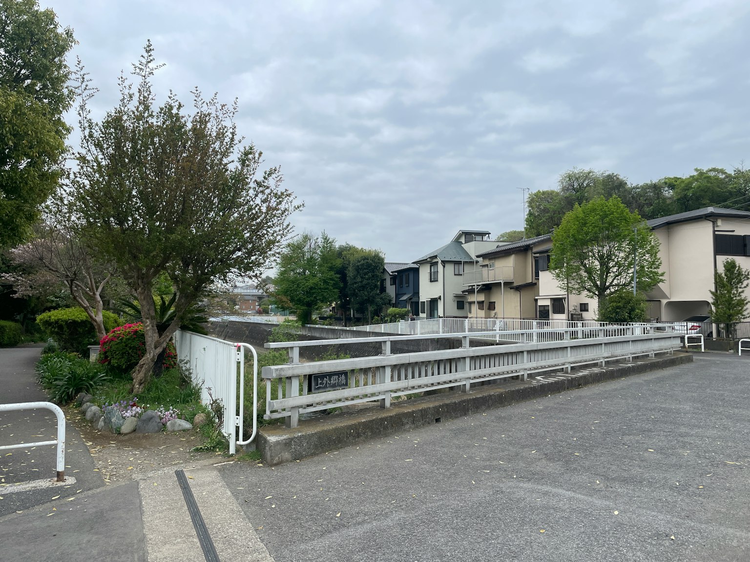 Une rue résidentielle calme avec un pont et une verdure luxuriante