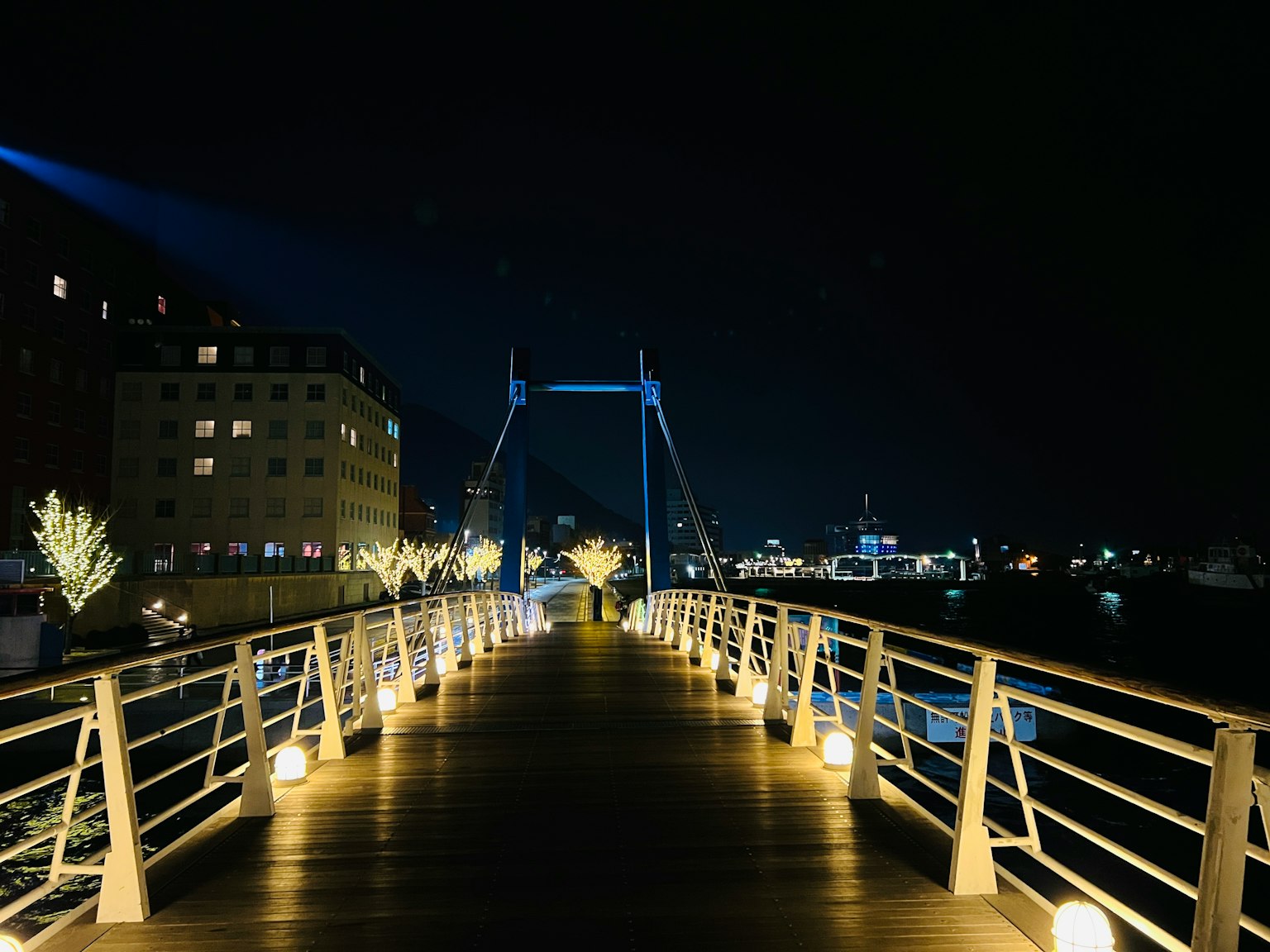 สะพานที่มีแสงสว่างในเวลากลางคืนพร้อมกับอาคารรอบข้าง