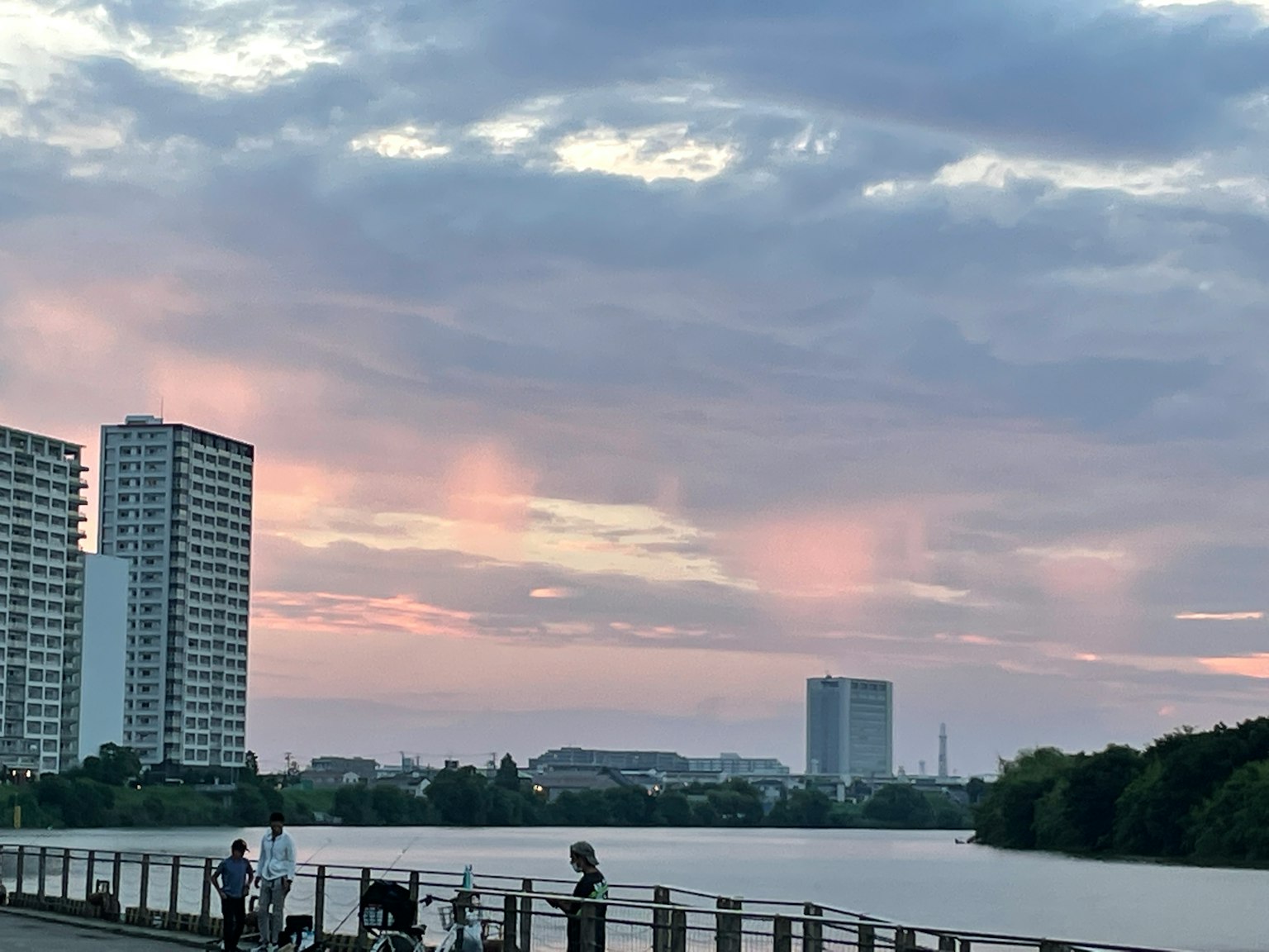 Malersiche Aussicht auf einen See mit pastellfarbenem Sonnenuntergang und Hochhäusern