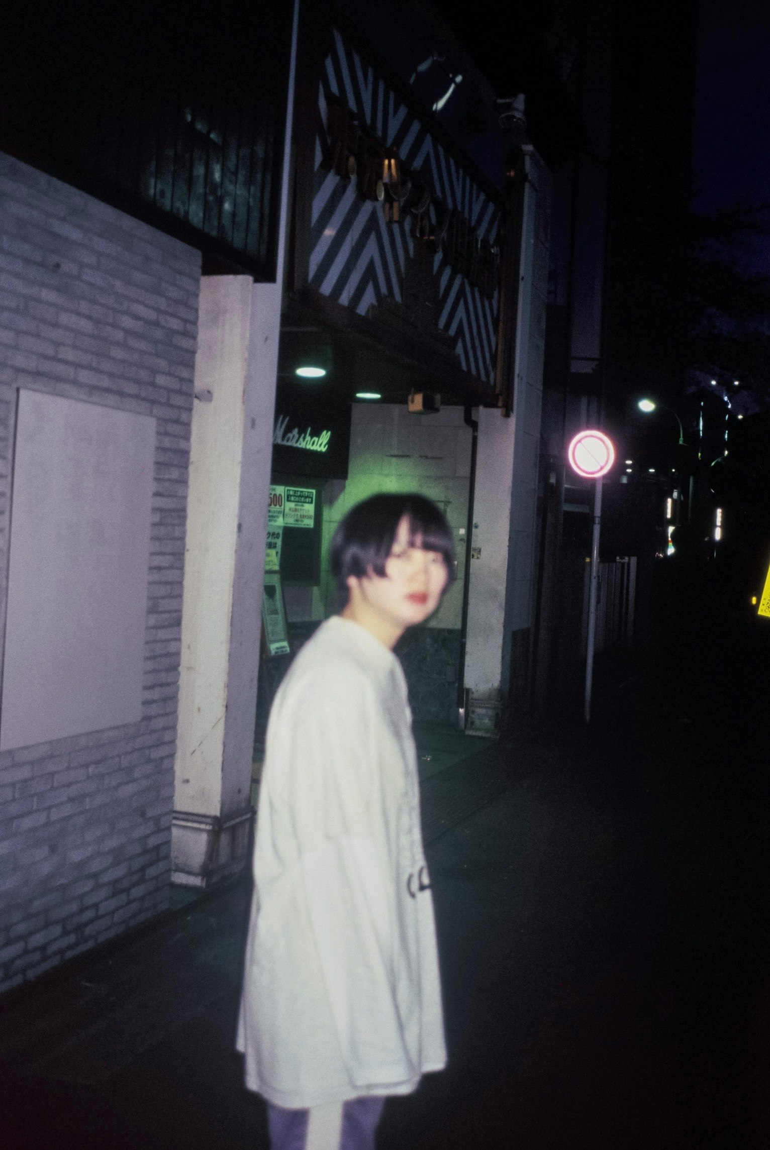 夜の路地で立つ女性