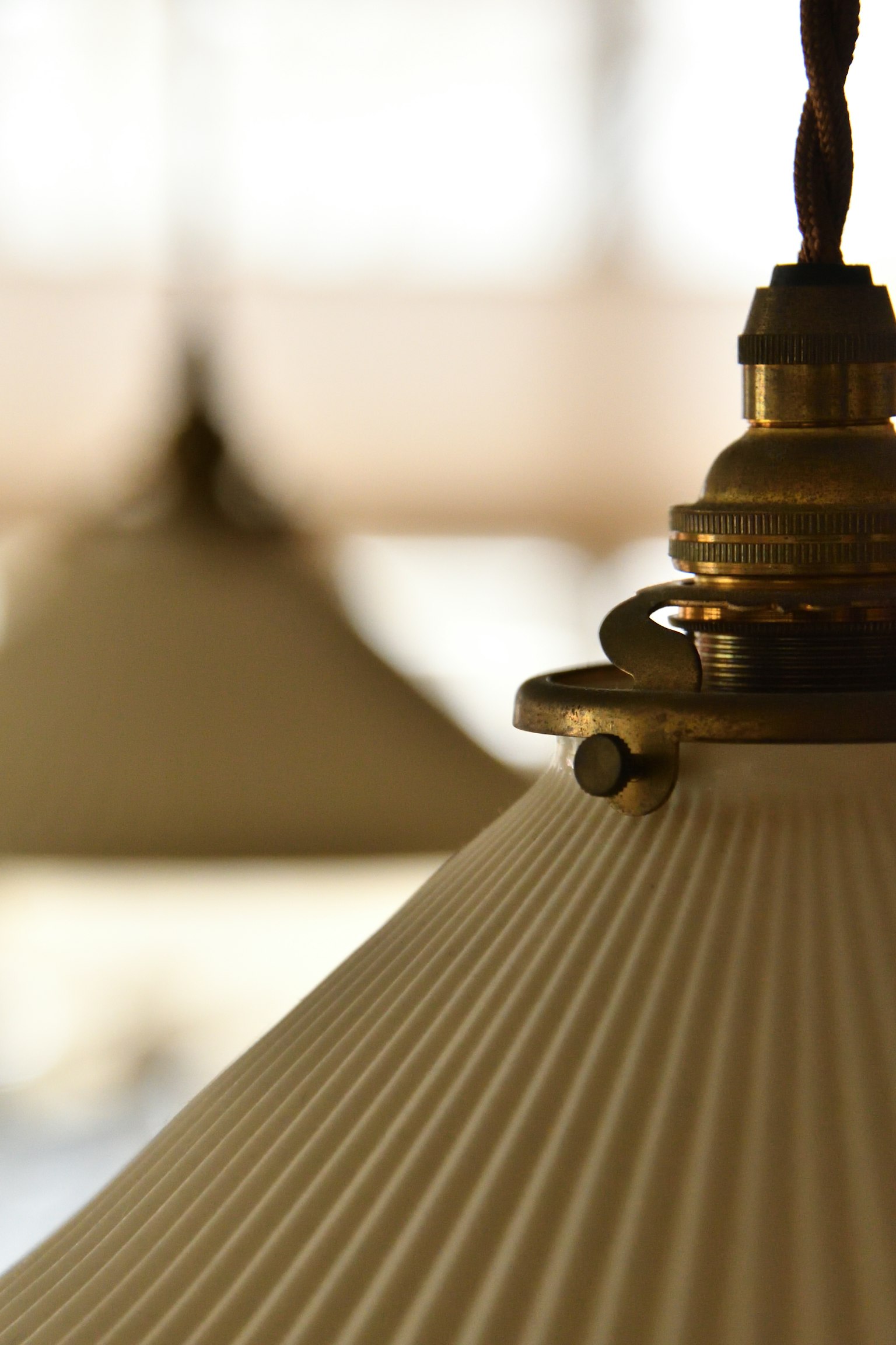 Close-up of a white lamp shade with intricate metal details
