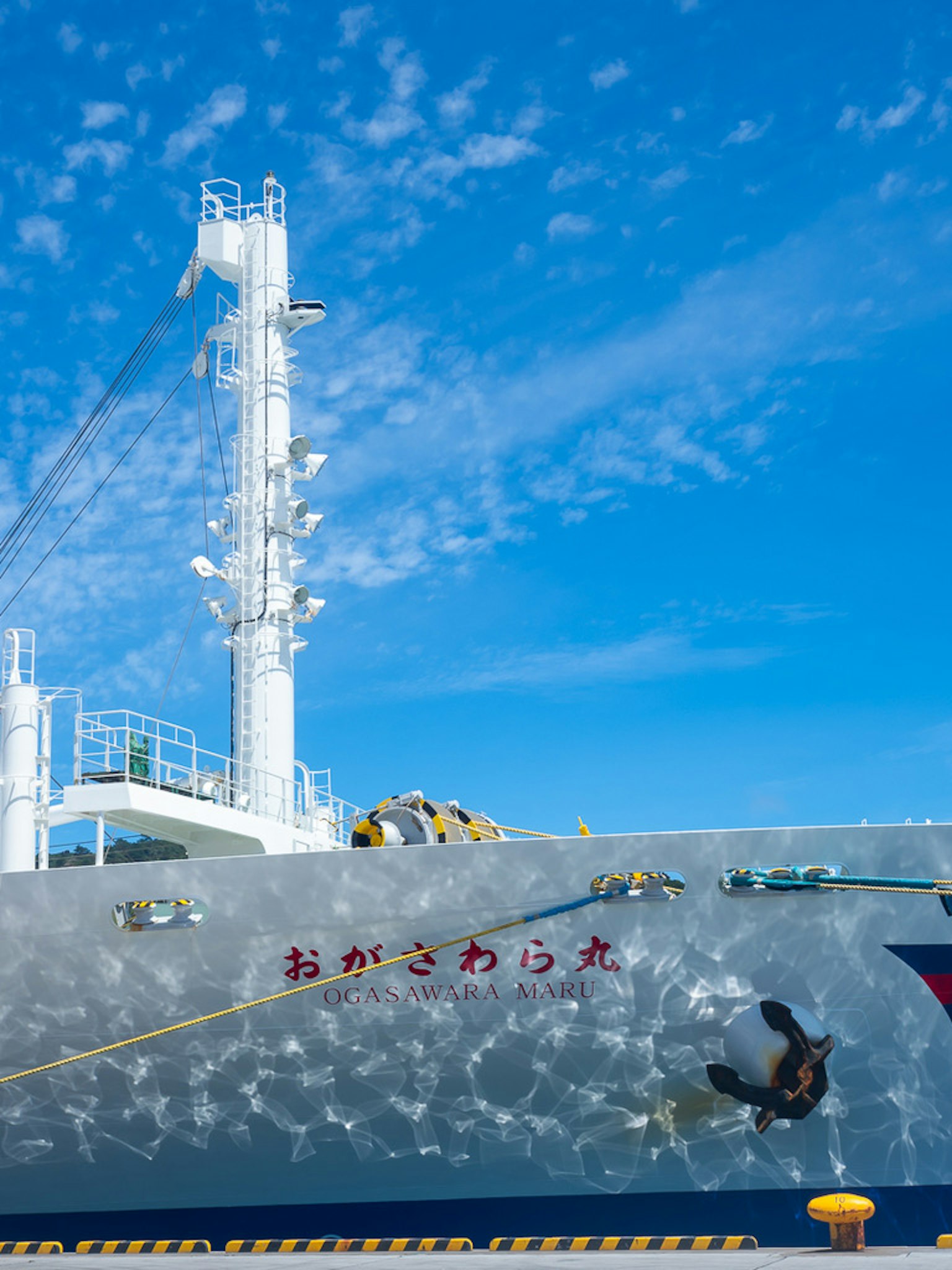 Buceador en el costado de un gran barco bajo un cielo azul