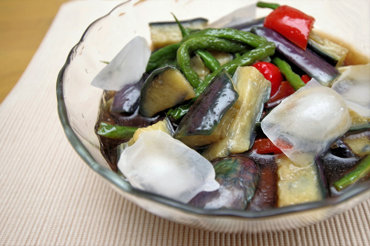 Piatto di verdure colorate in una ciotola trasparente con cubetti di ghiaccio
