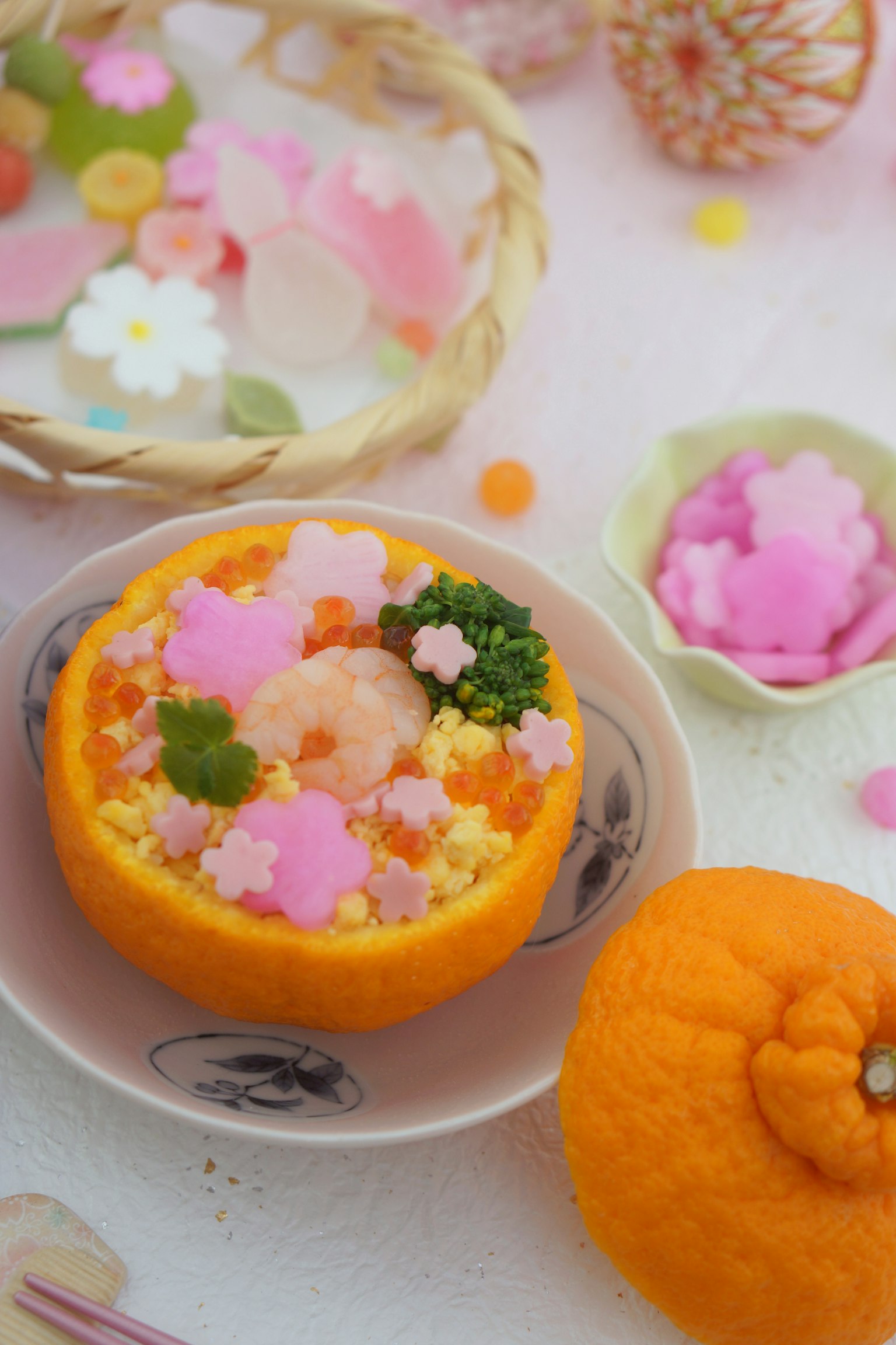 Buntes Dessert in einer orangenen Schale mit floralen Dekorationen serviert