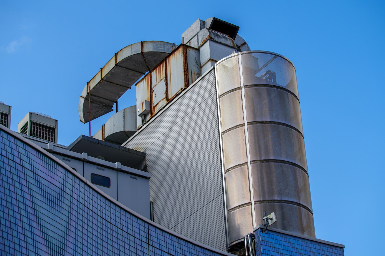 Estructura superior de un edificio industrial con arquitectura moderna contra un cielo azul