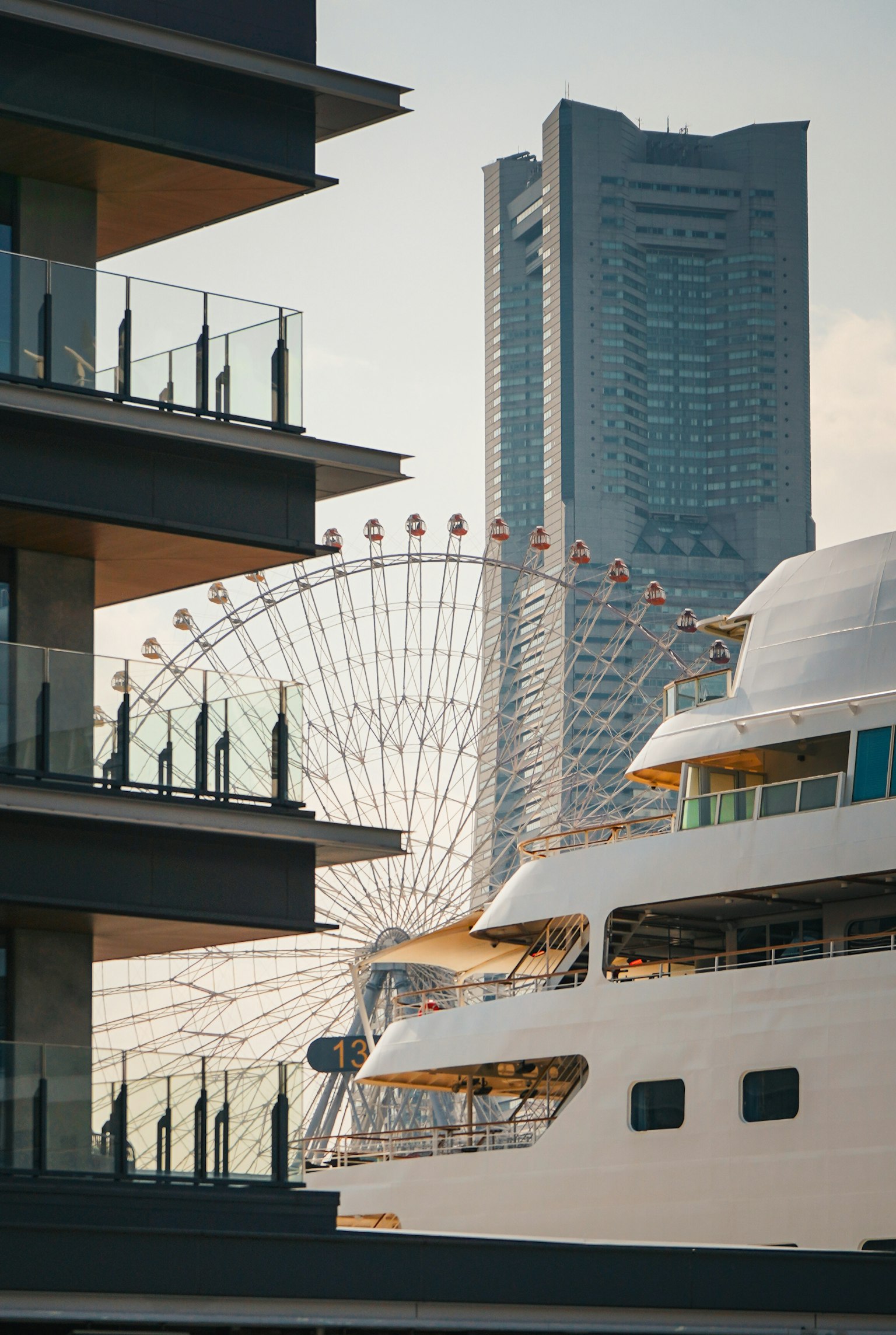 Yacht mewah dengan gedung tinggi dan roda raksasa di latar belakang