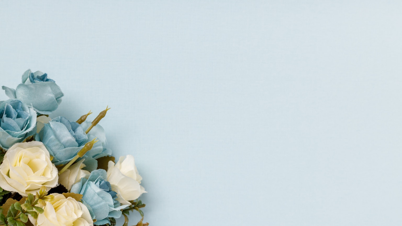 Ein Strauß aus blassen blauen und weißen Blumen vor einem hellblauen Hintergrund