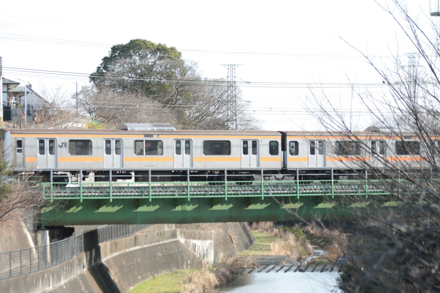 Train orange et blanc traversant une rivière