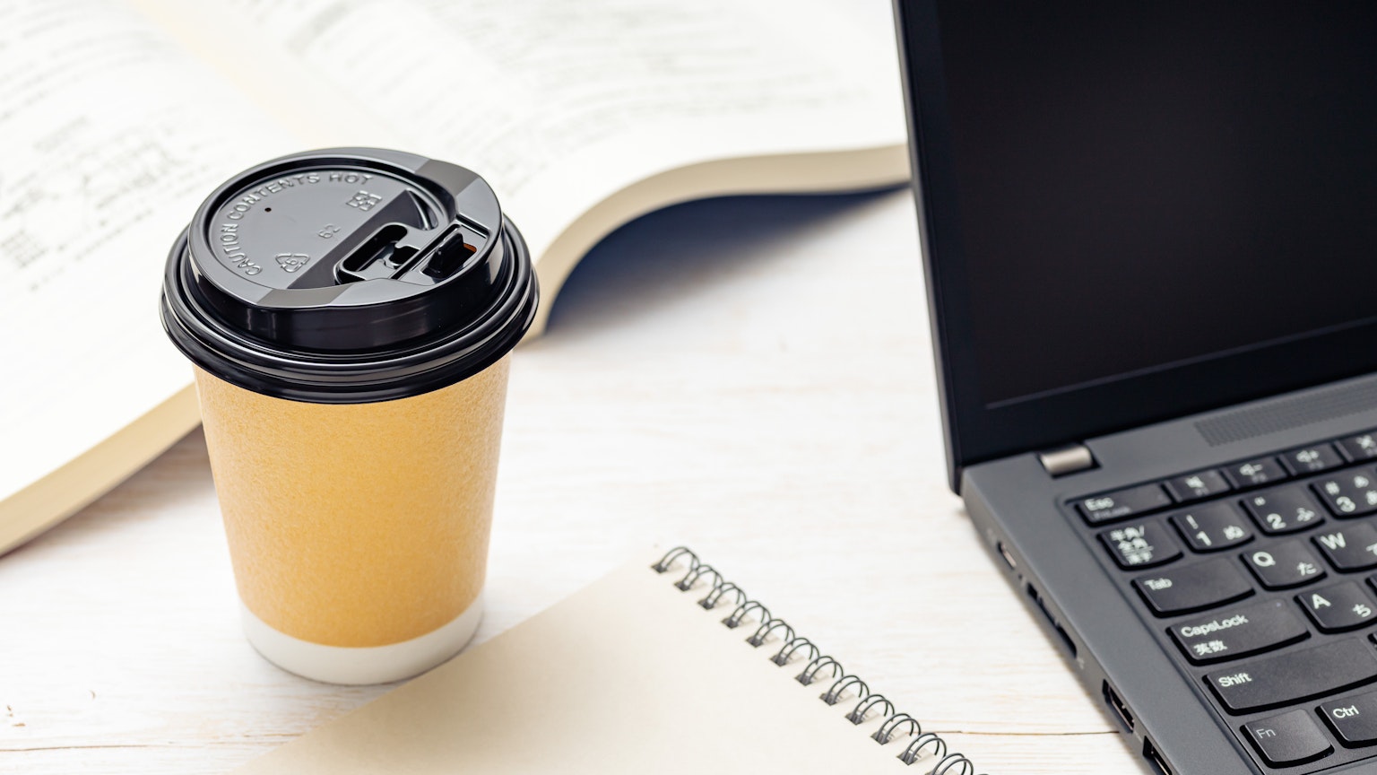 Kaffeetasse und Laptop auf einem Schreibtisch
